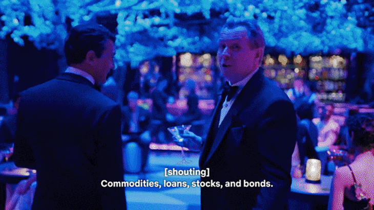 Men in tuxedos converse in a crowded, blue-lit event space. Subtitles read "[shouting] Commodities, loans, stocks, and bonds."