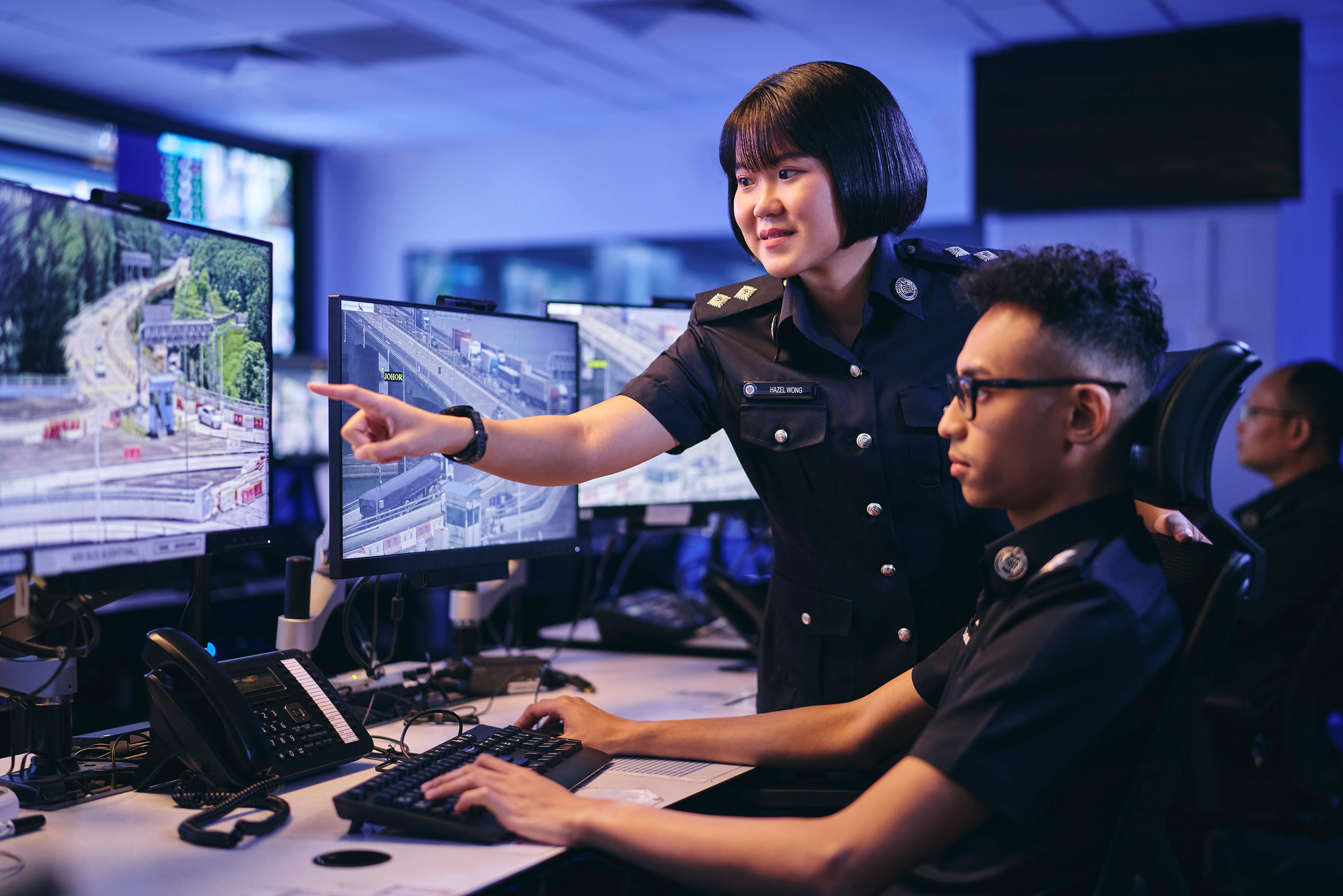 Two uniformed officers engaged in discussion at a security facility.