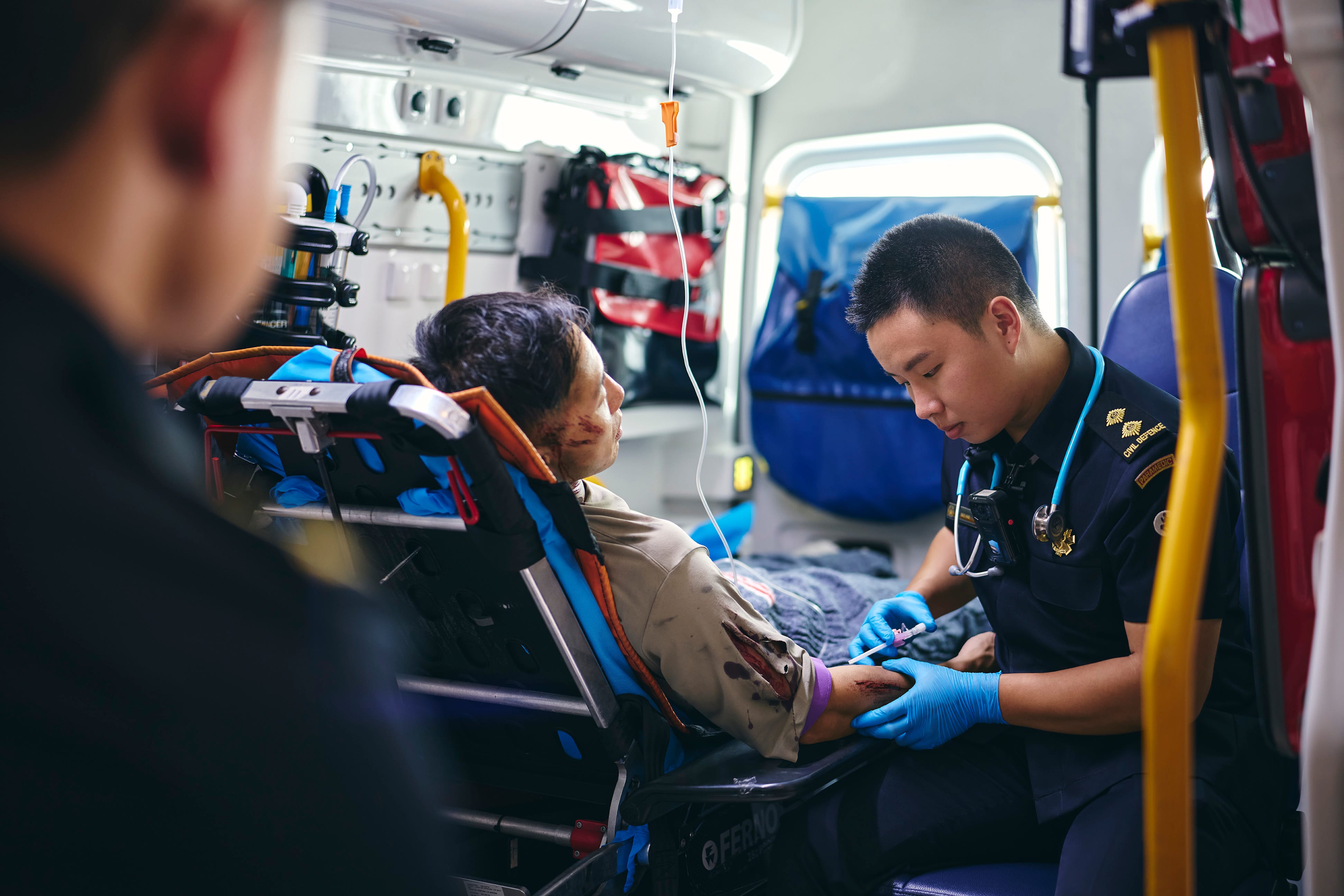 Paramedics attending to an injured person inside an ambulance.