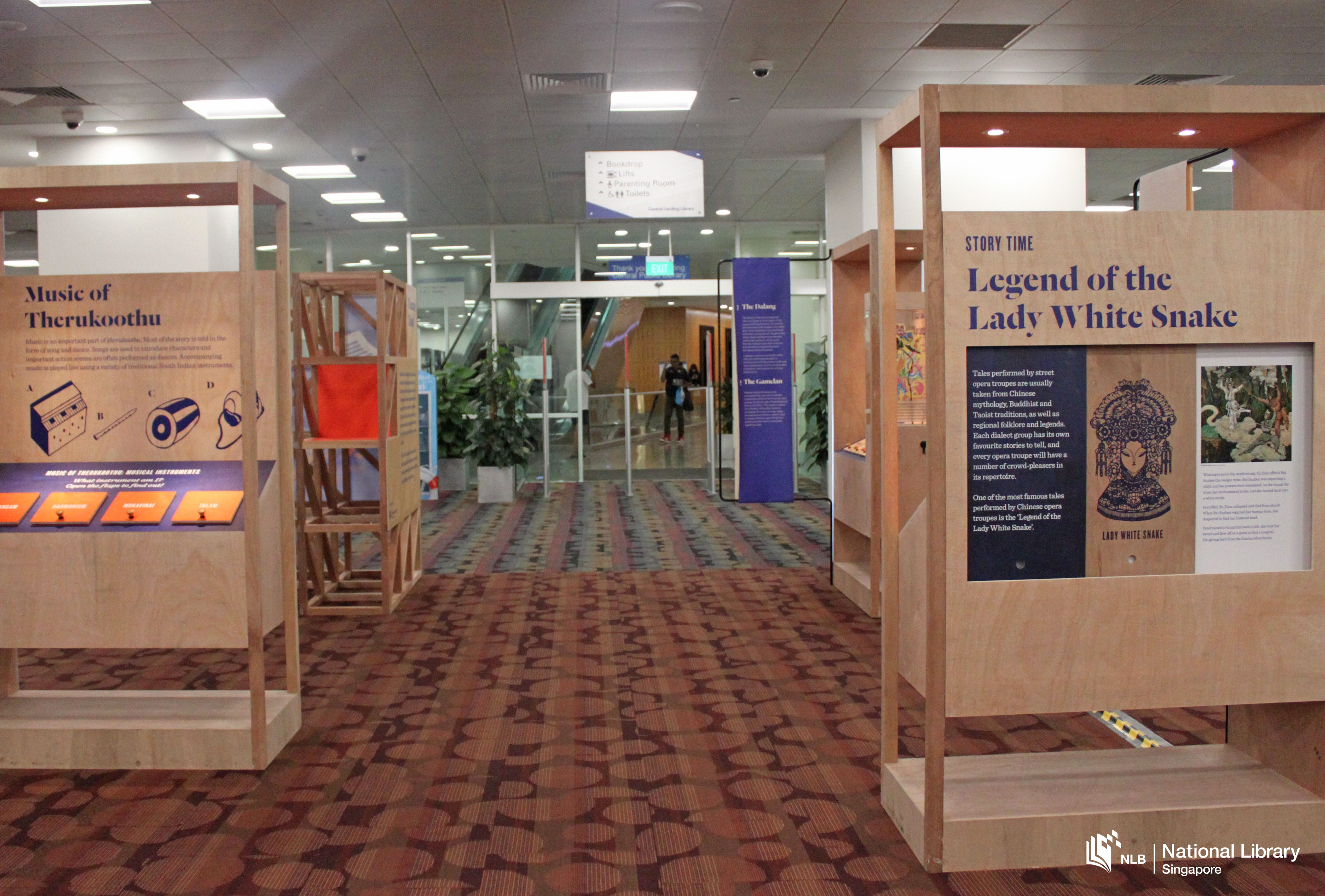 Library hallway with cultural exhibit panels, including "Legend of the Lady White Snake" and "Music of Therukoothu".