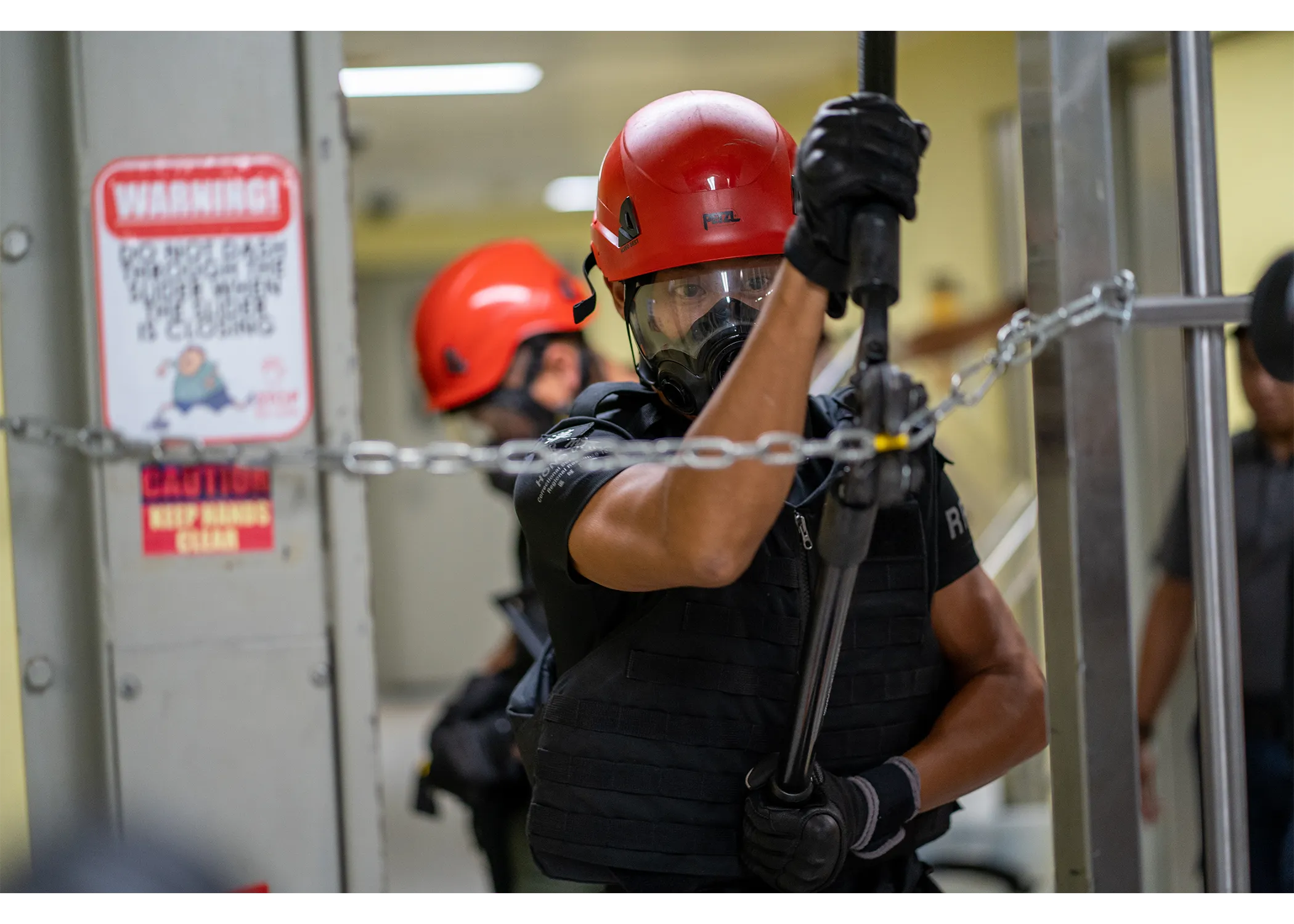 close up photograph of an officer cutting the chain using the chain cutting tool