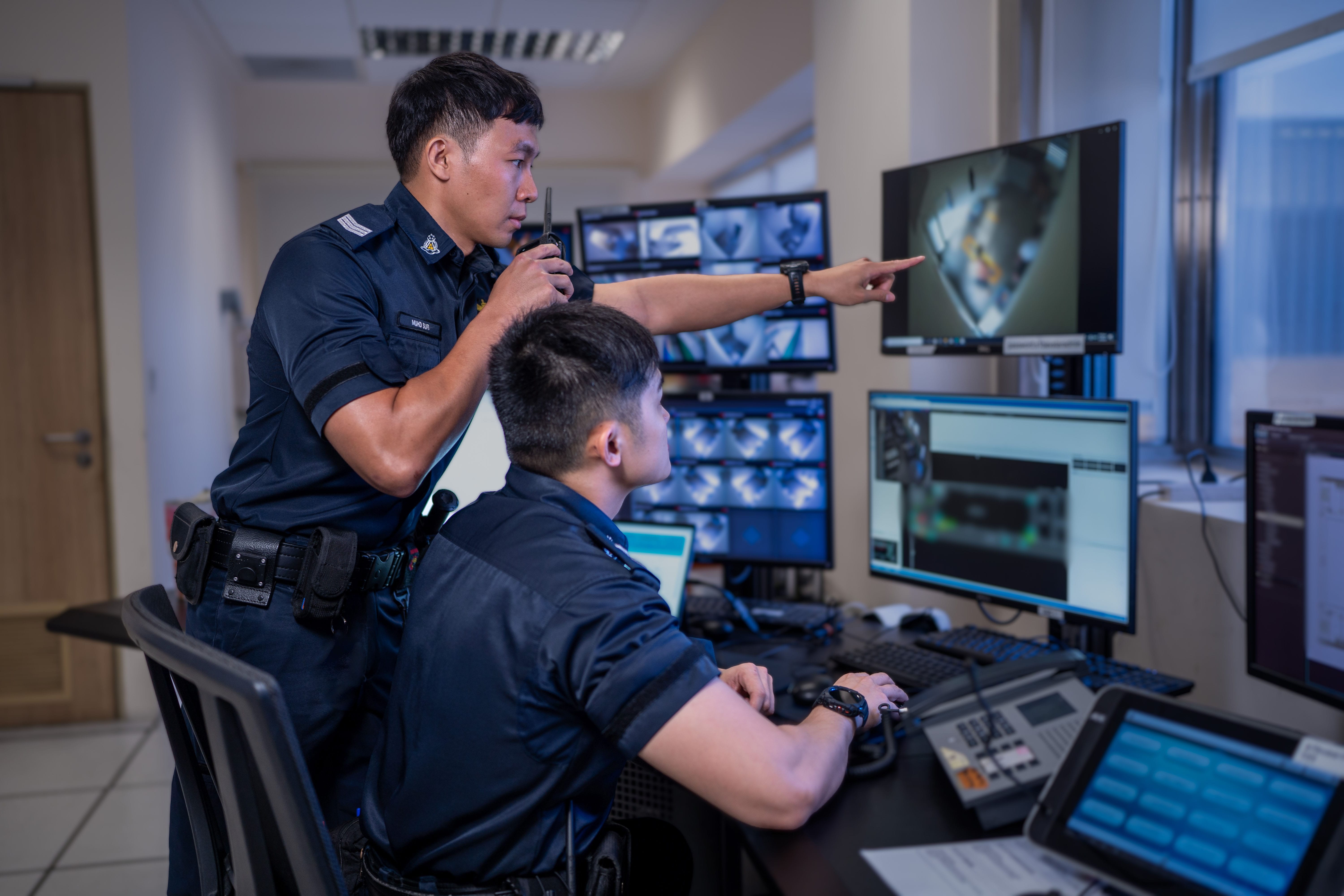 An officer in uniform using a device.