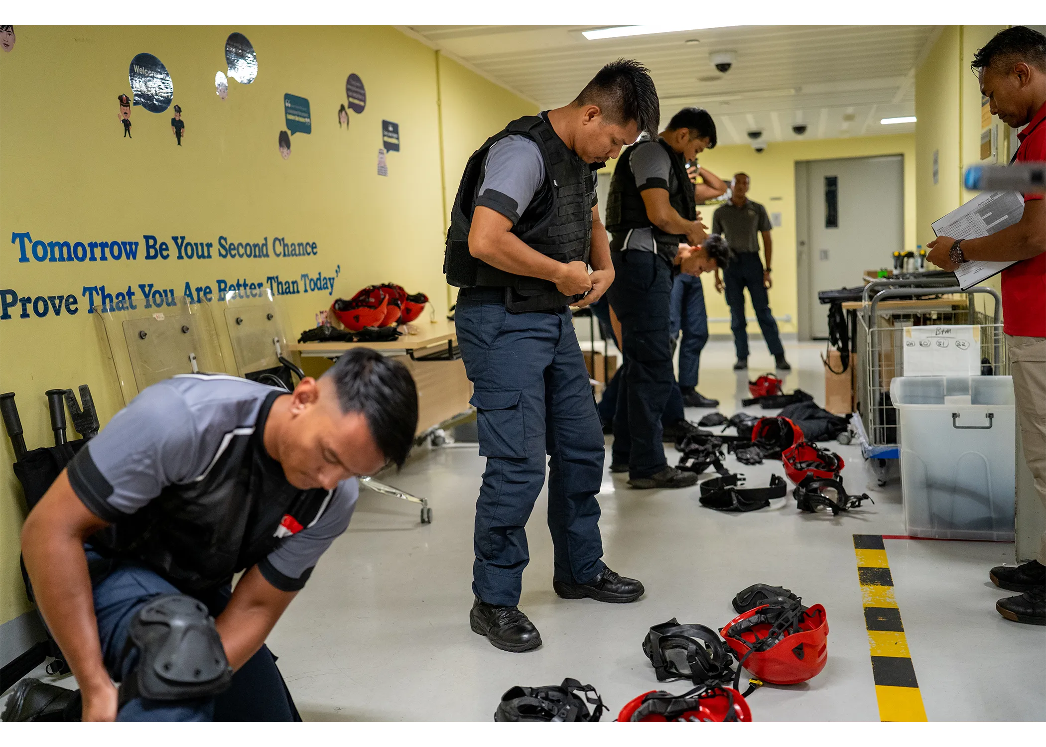 Group of officers standing in line and donning their tactical gear.