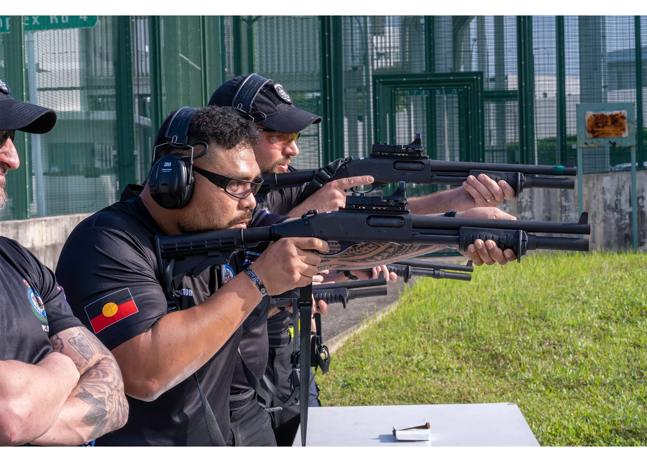 Photograph of officers looking down the iron sight of their rifle, pointing down range and ready to shoot