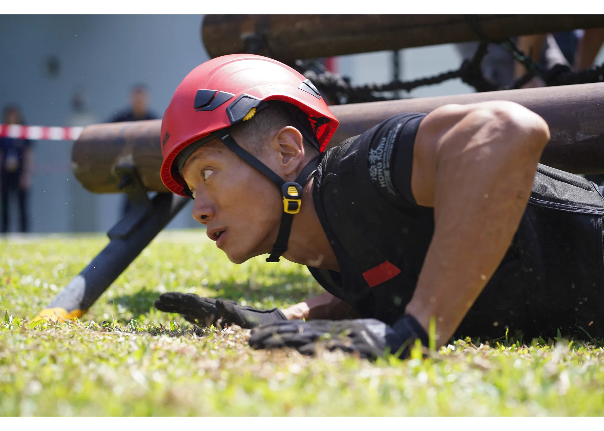 An officer pushing himself up from the ground after crawling under the log station
