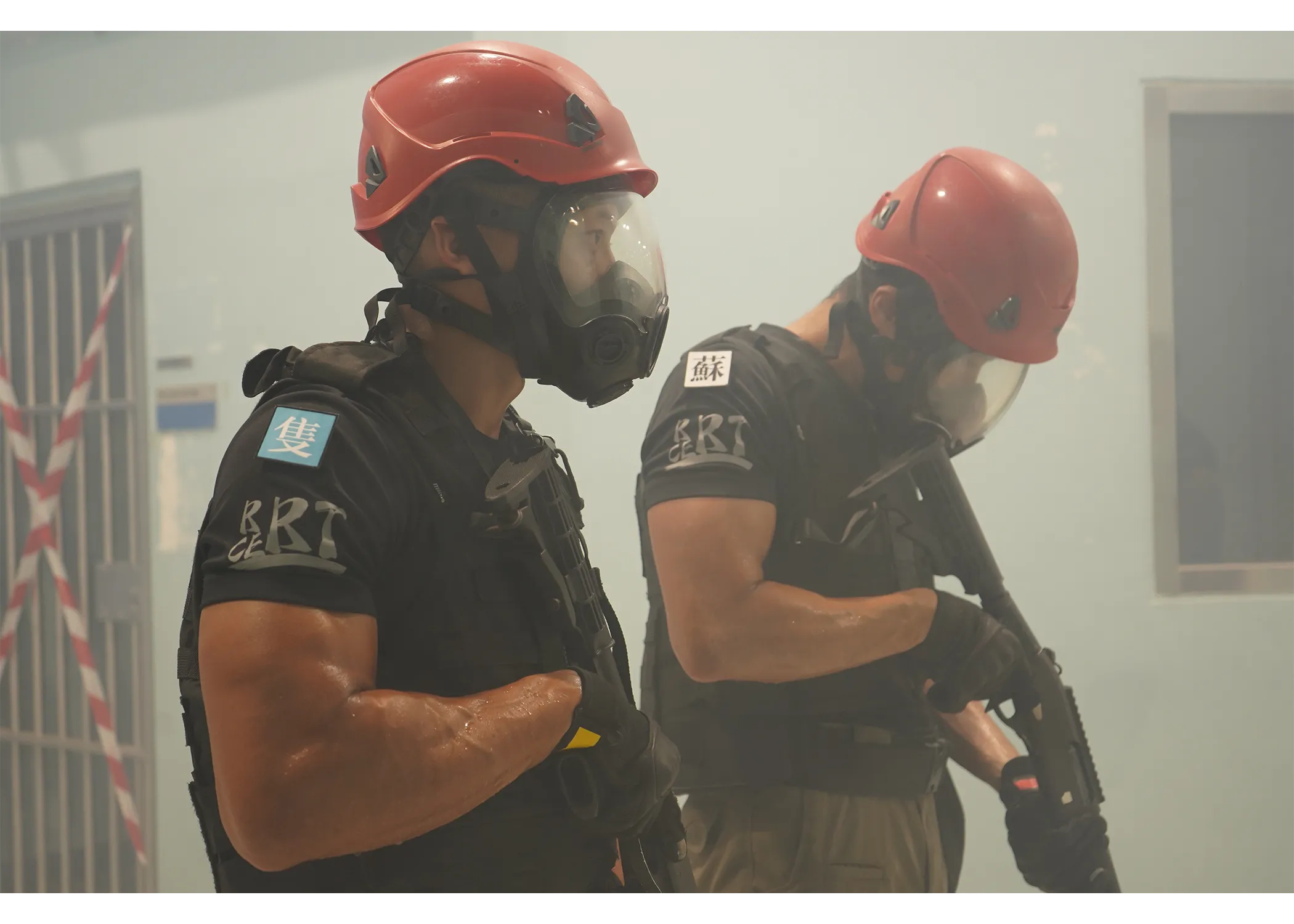 Two officers with gas mask and rifle on during an indoor APLC event simulating a prison contingency. 