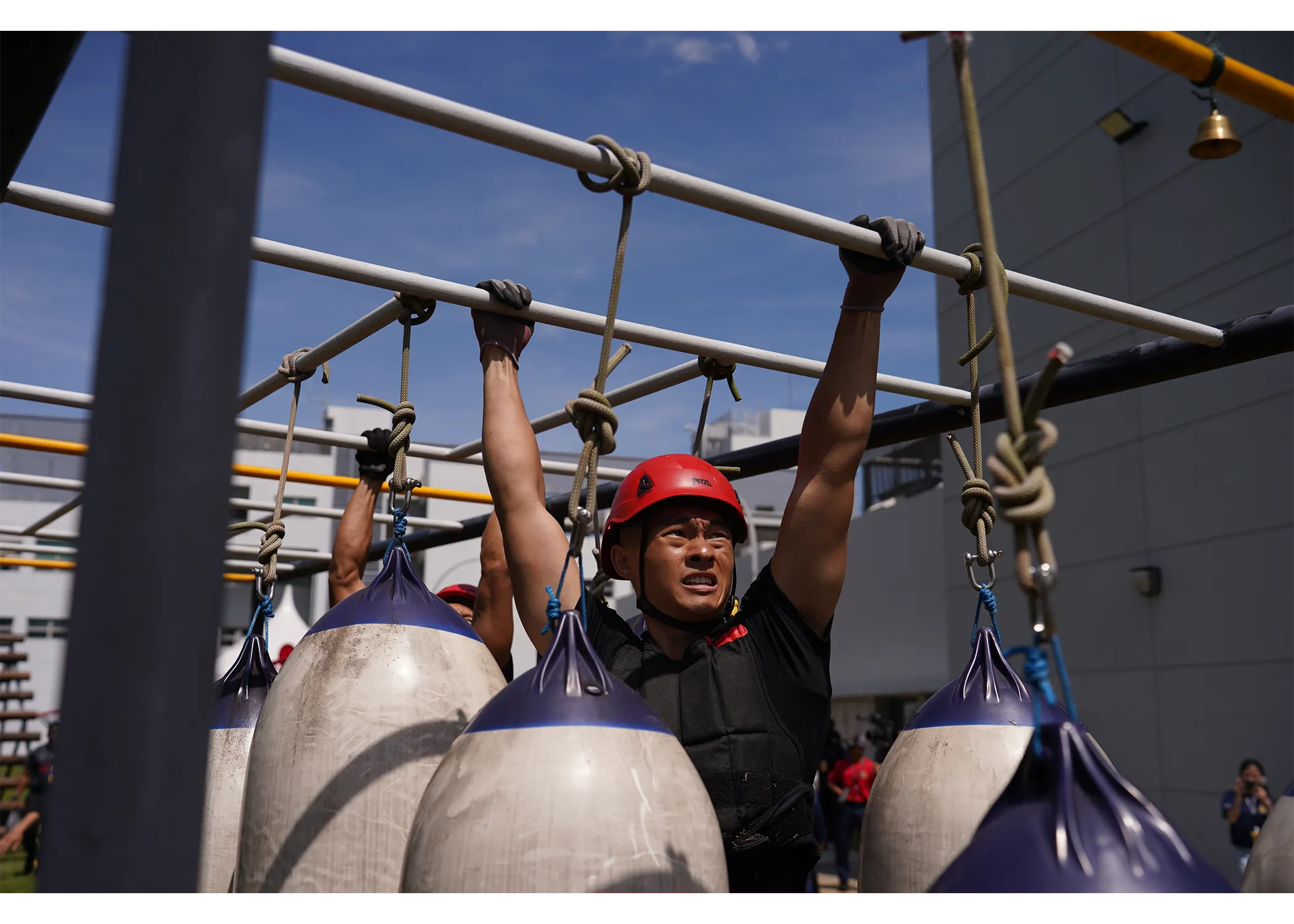 An officer climbing across the monkey bar station