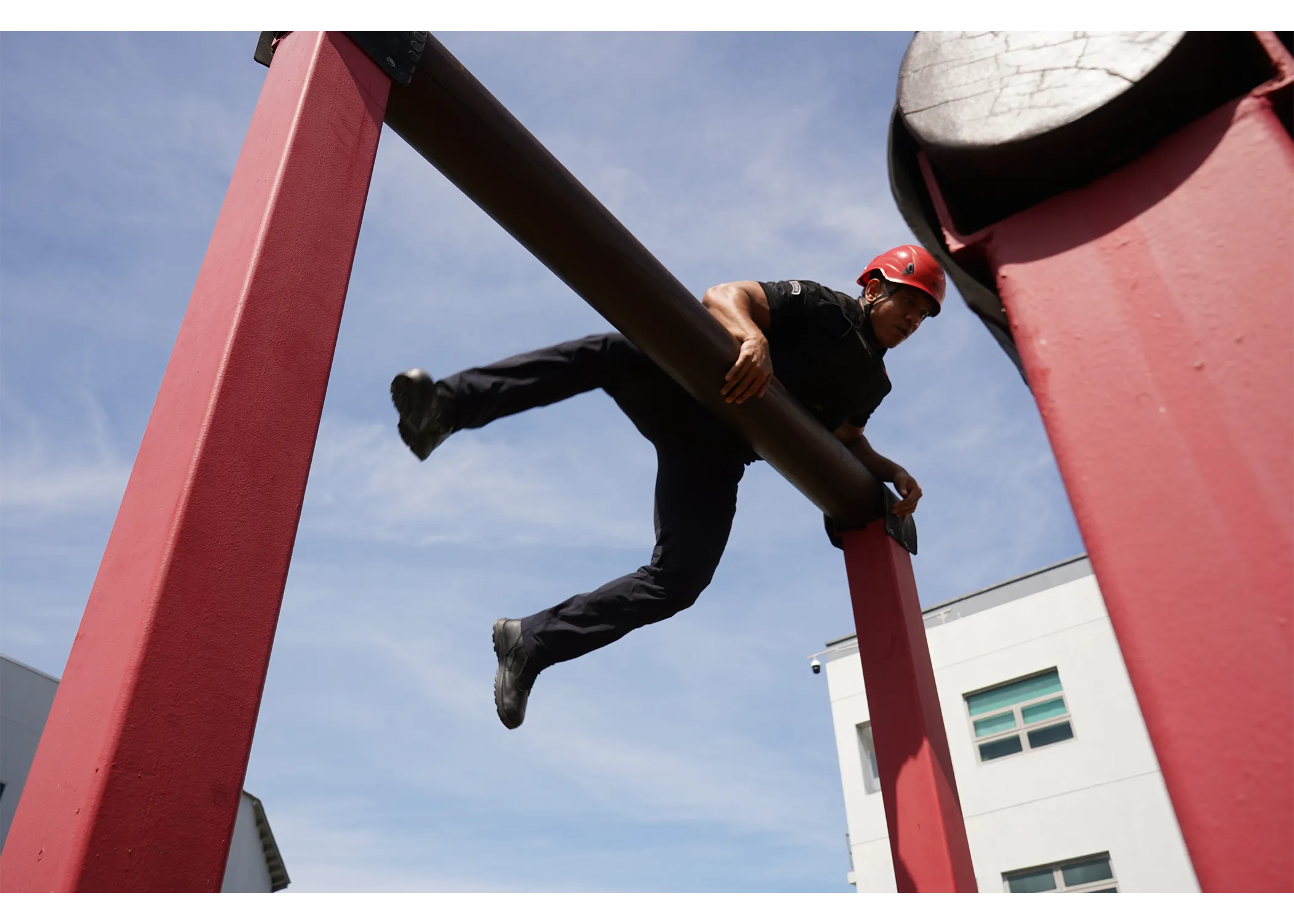 An officer climbing over the high log obstacle course during APLC Event