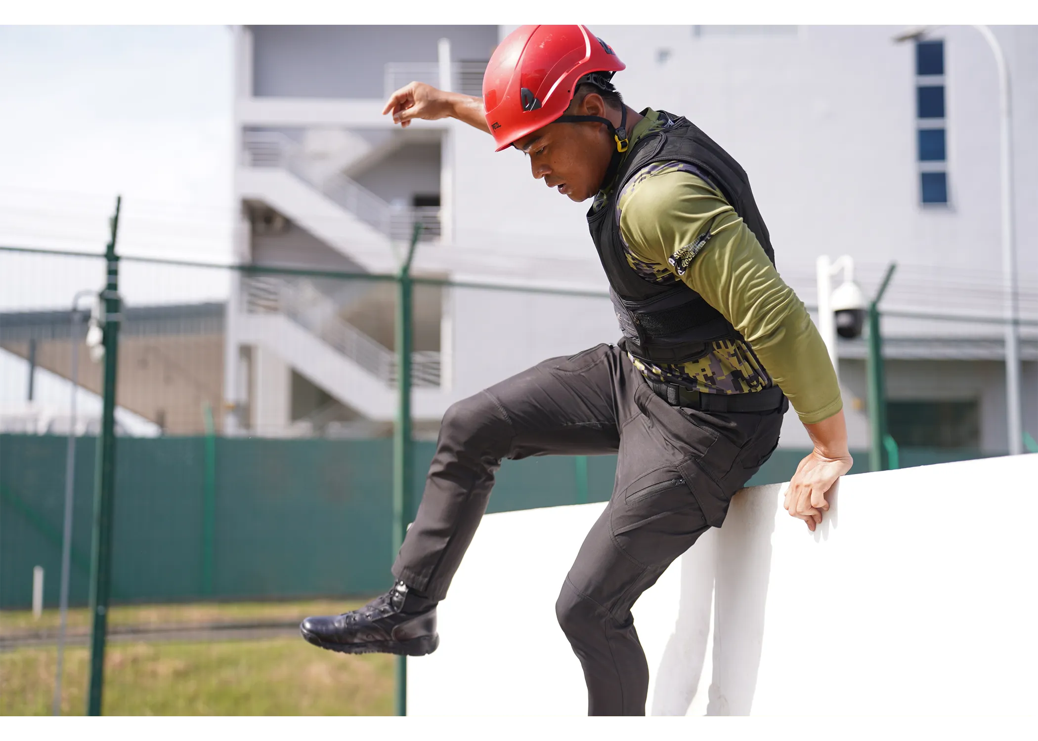 An officer jumping down from the low wall station