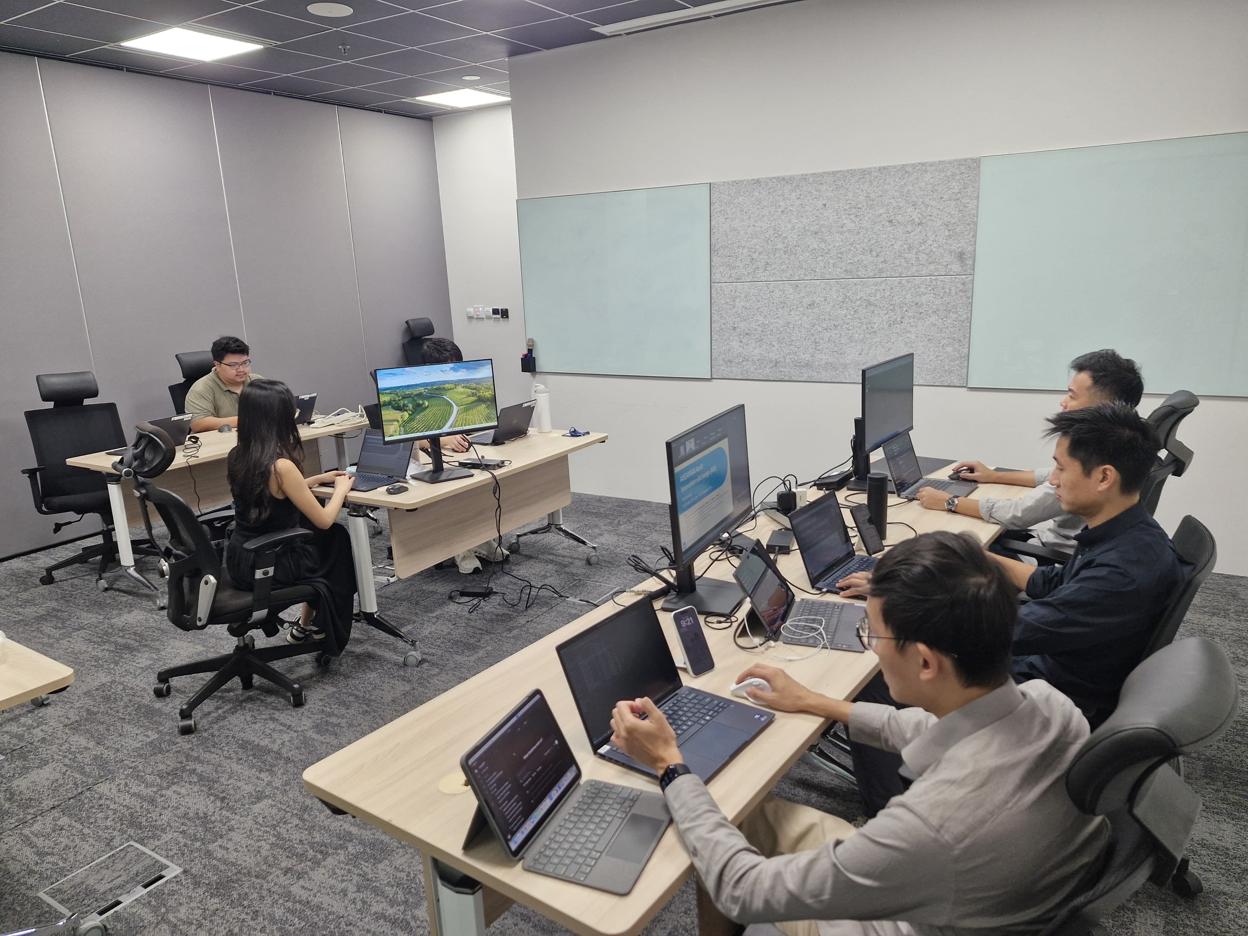 A group of people seated in front of laptops in a seminar room
