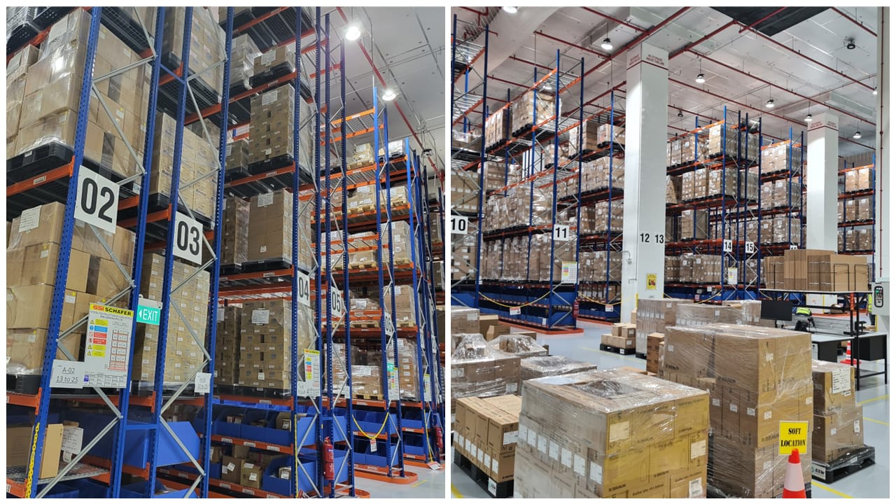 A large warehouse with tall racks filled with boxes, marked with numbered locations, and stacked parcels on the floor.