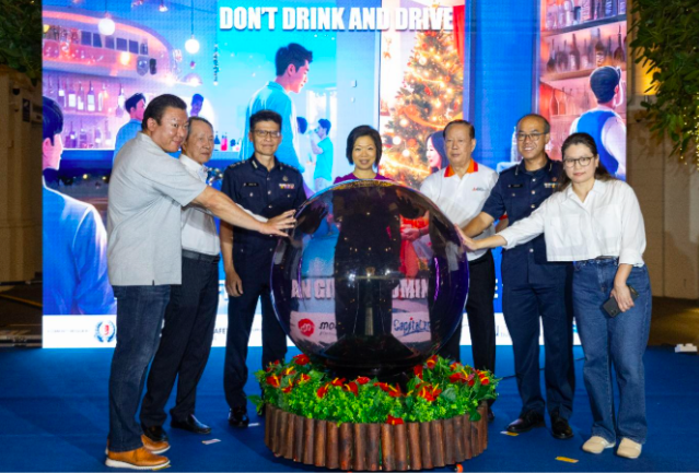 A group of people stands behind a large sphere, with a "DON'T DRINK AND DRIVE" message displayed in the background.