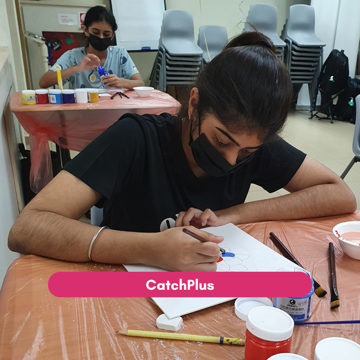 Youth participant paints a canvas during a CatchPlus art activity.