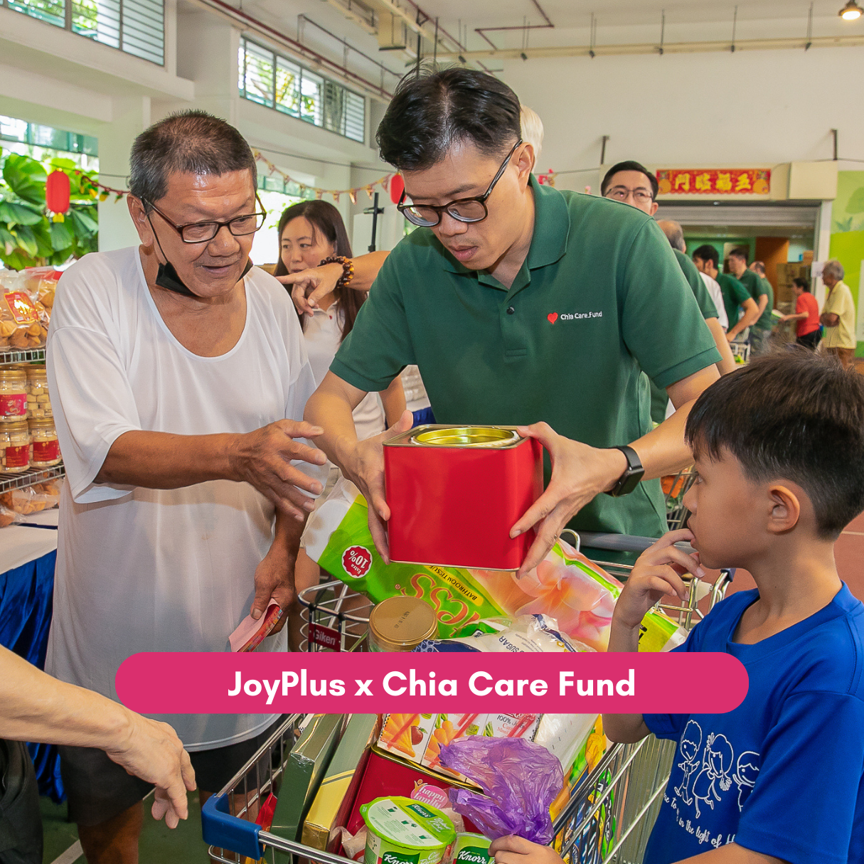 Volunteer helps senior select groceries during JoyPlus community support event.