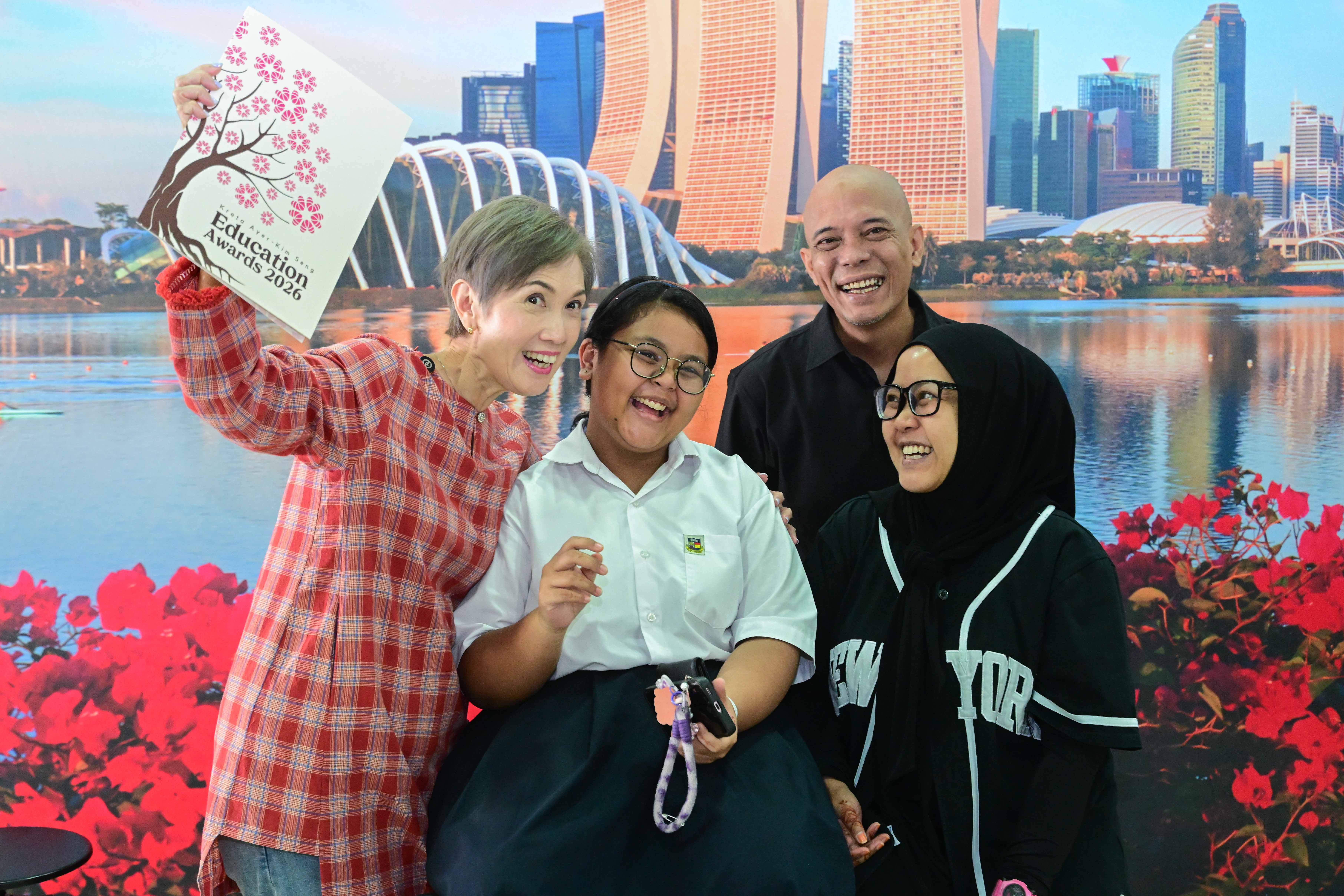 Group smiling at KT King Education Awards 2026 with Singapore skyline backdrop.