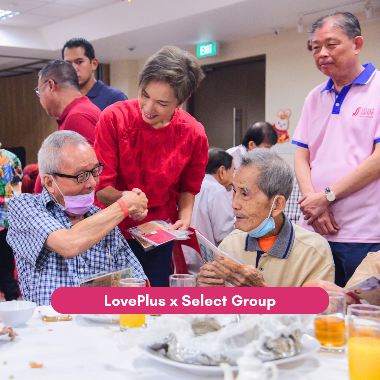 Community volunteer greets seniors and distributes gifts at LovePlus event.