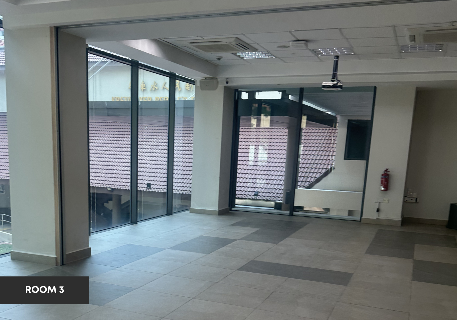 Pre-function room with large windows overlooking surrounding buildings.
