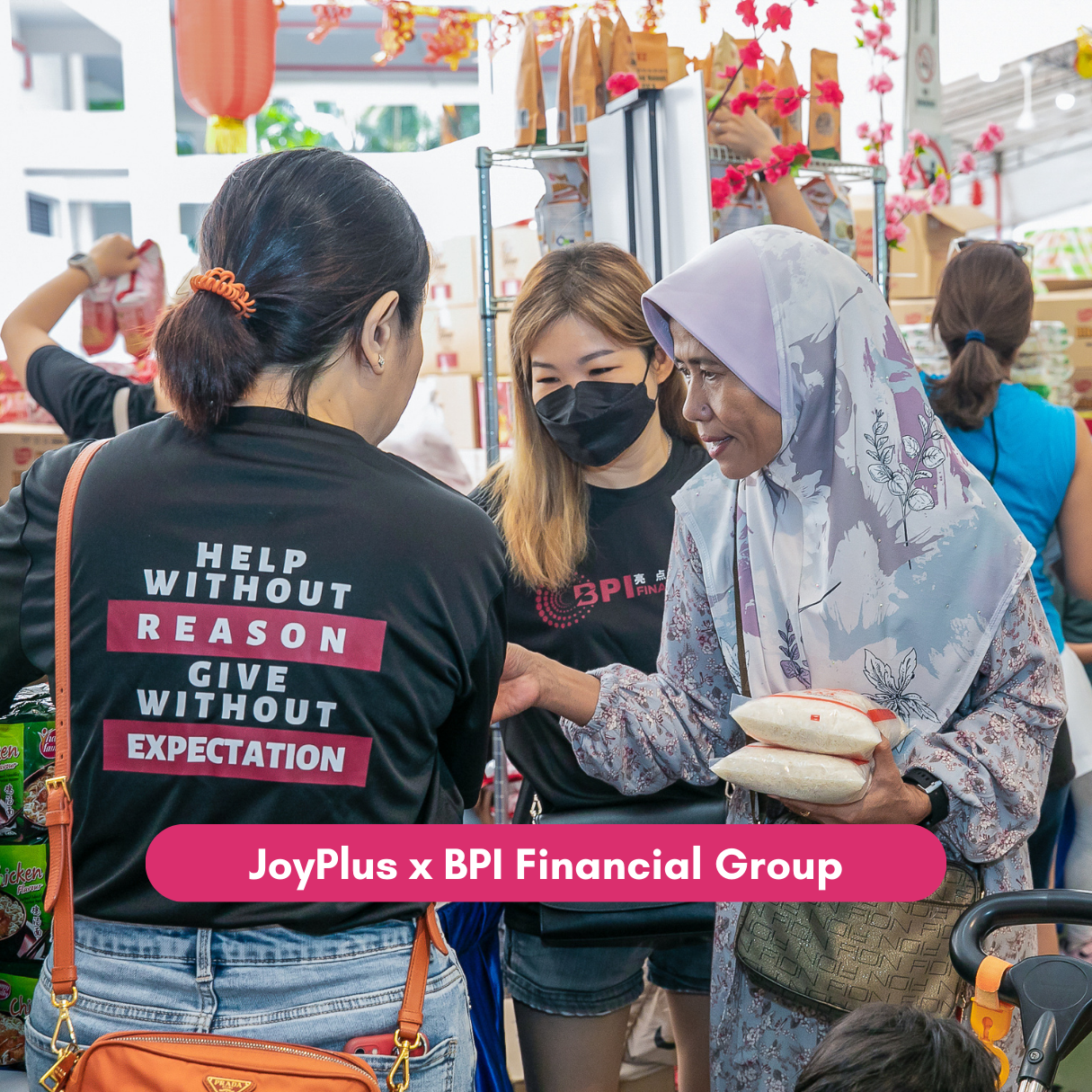 Volunteer assists resident collecting groceries at JoyPlus community market