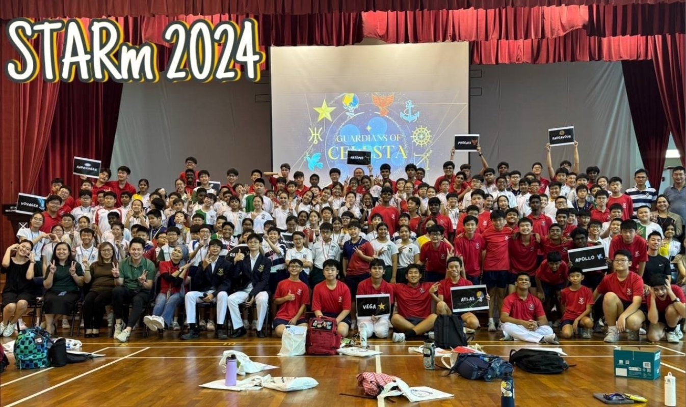 Large group of students posing in a school hall at STARm 2024 event with a Guardians of Celesta backdrop.