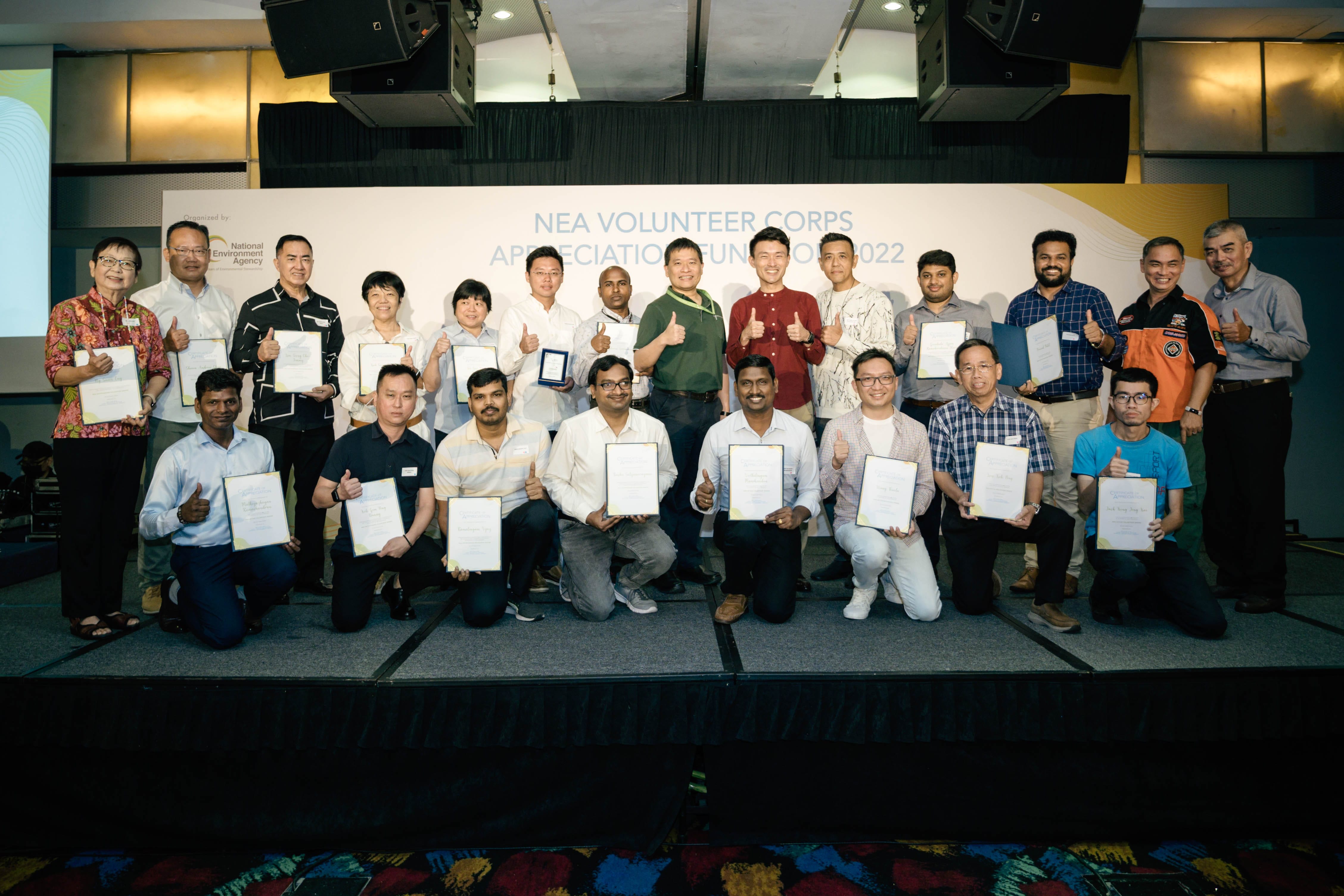 Group of people holding certificates on stage at the NEA Volunteer Corps Appreciation Function 2022.