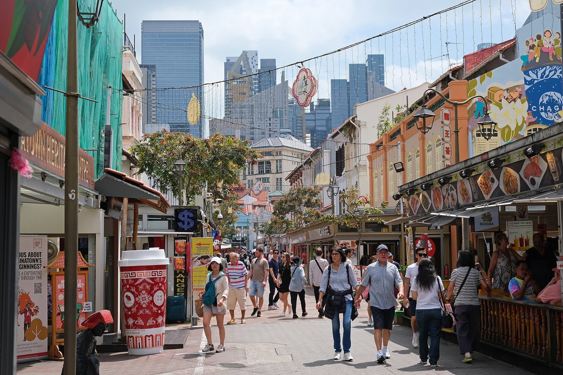 A bustling city intersection with historic buildings and a colorful arch, text reads "Chinatown & Its Streets" and "Start Your Journey."