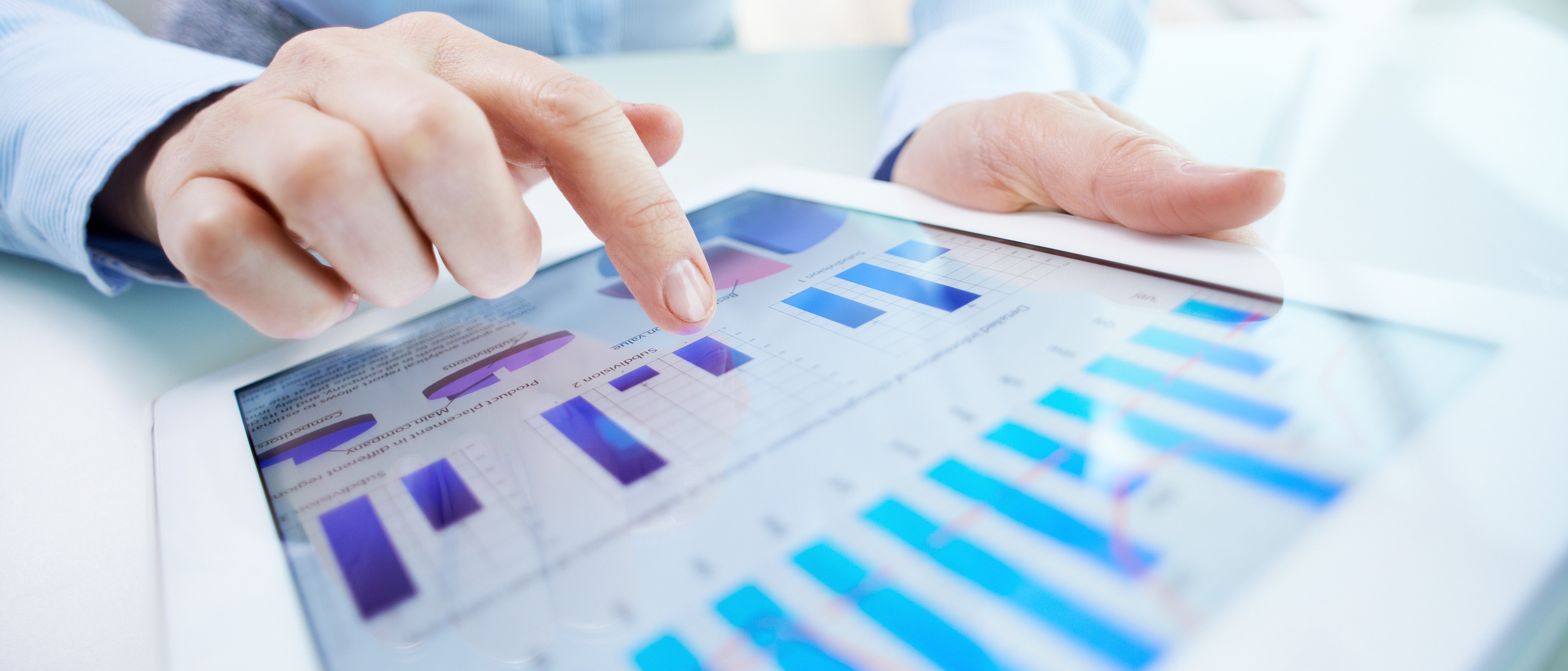 Close-up of a tablet displaying business charts and graphs, representing digital transformation and economic analytics.
