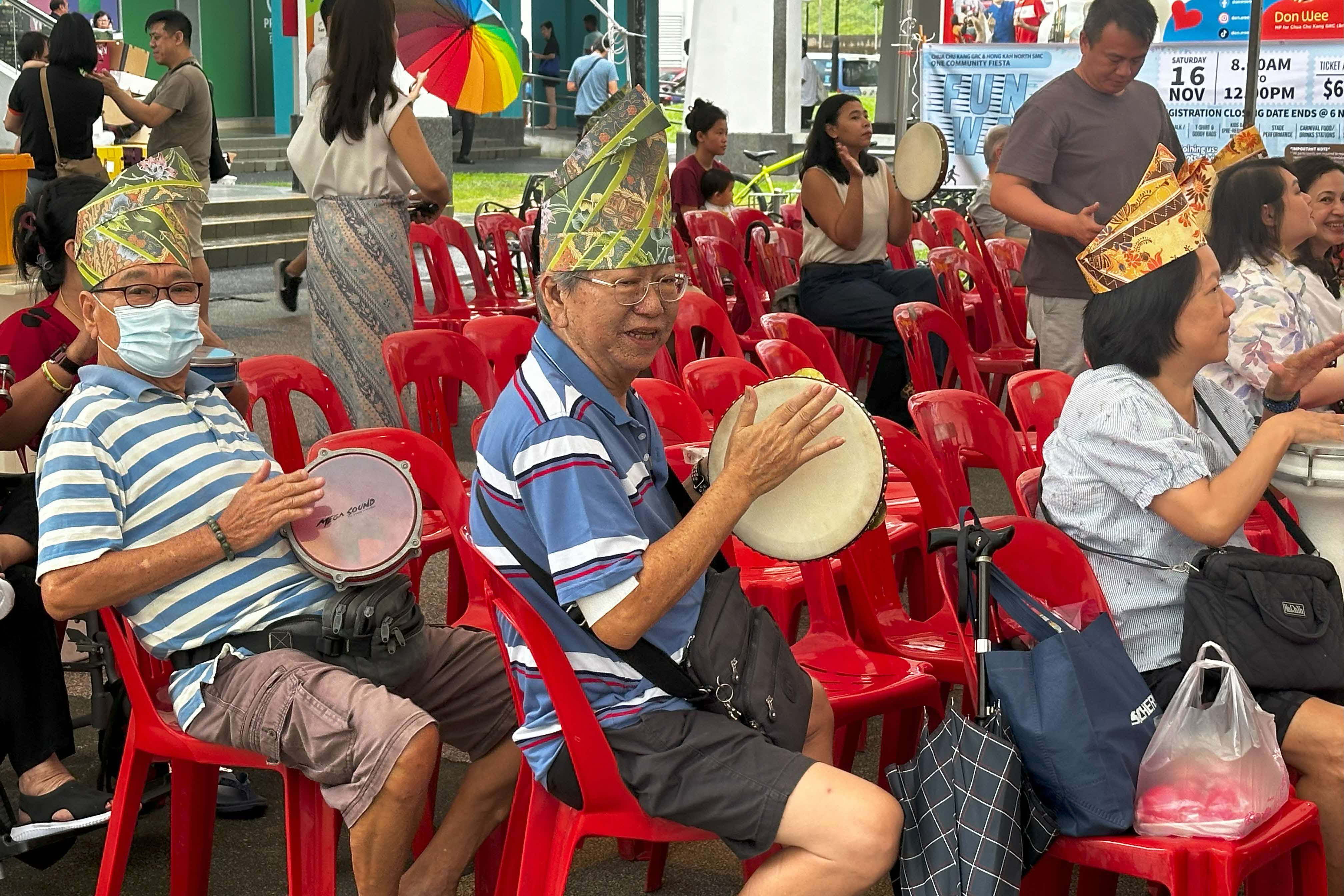 Audience members young and old learning how to play the kompang