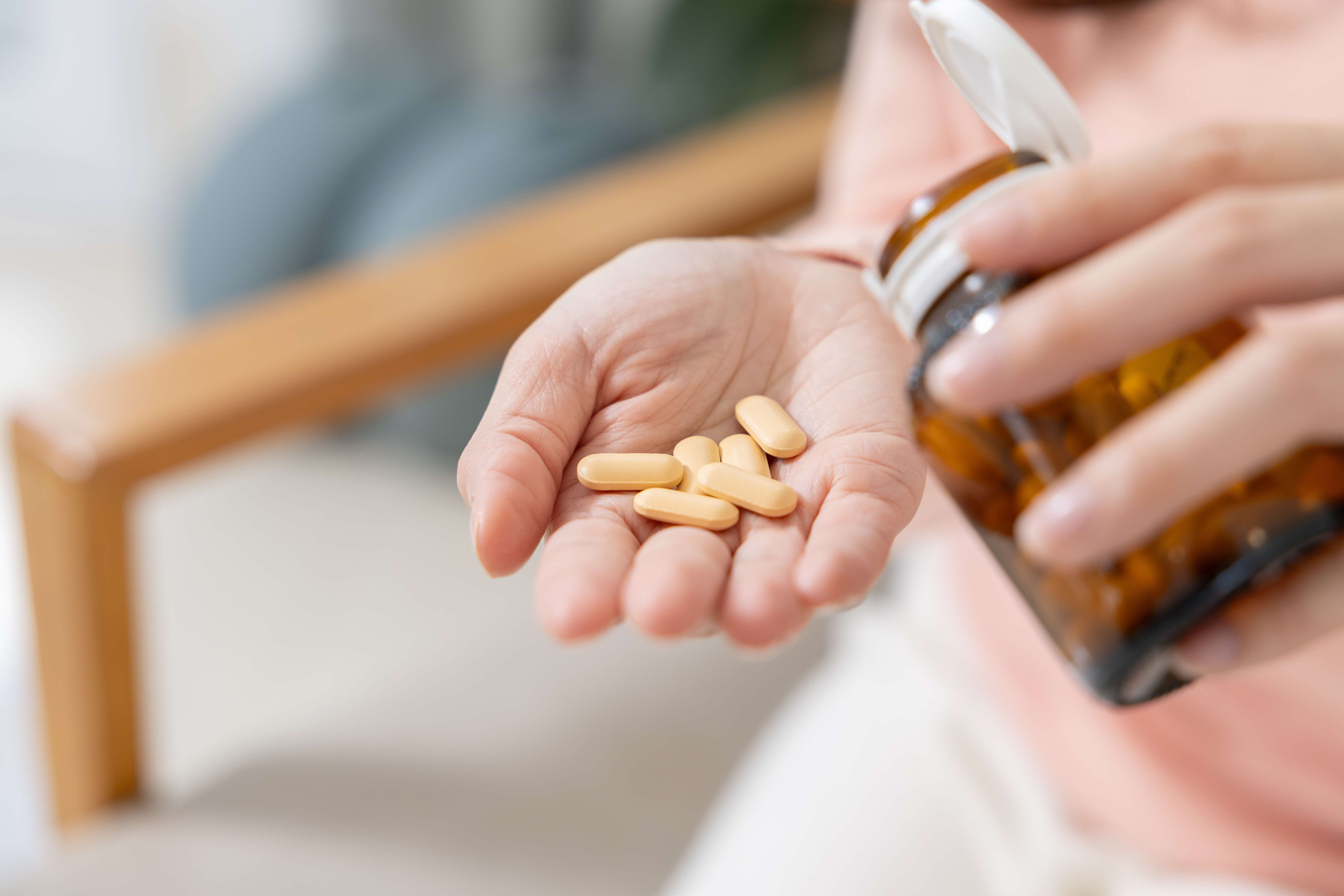 person pouring pills out from a bottle