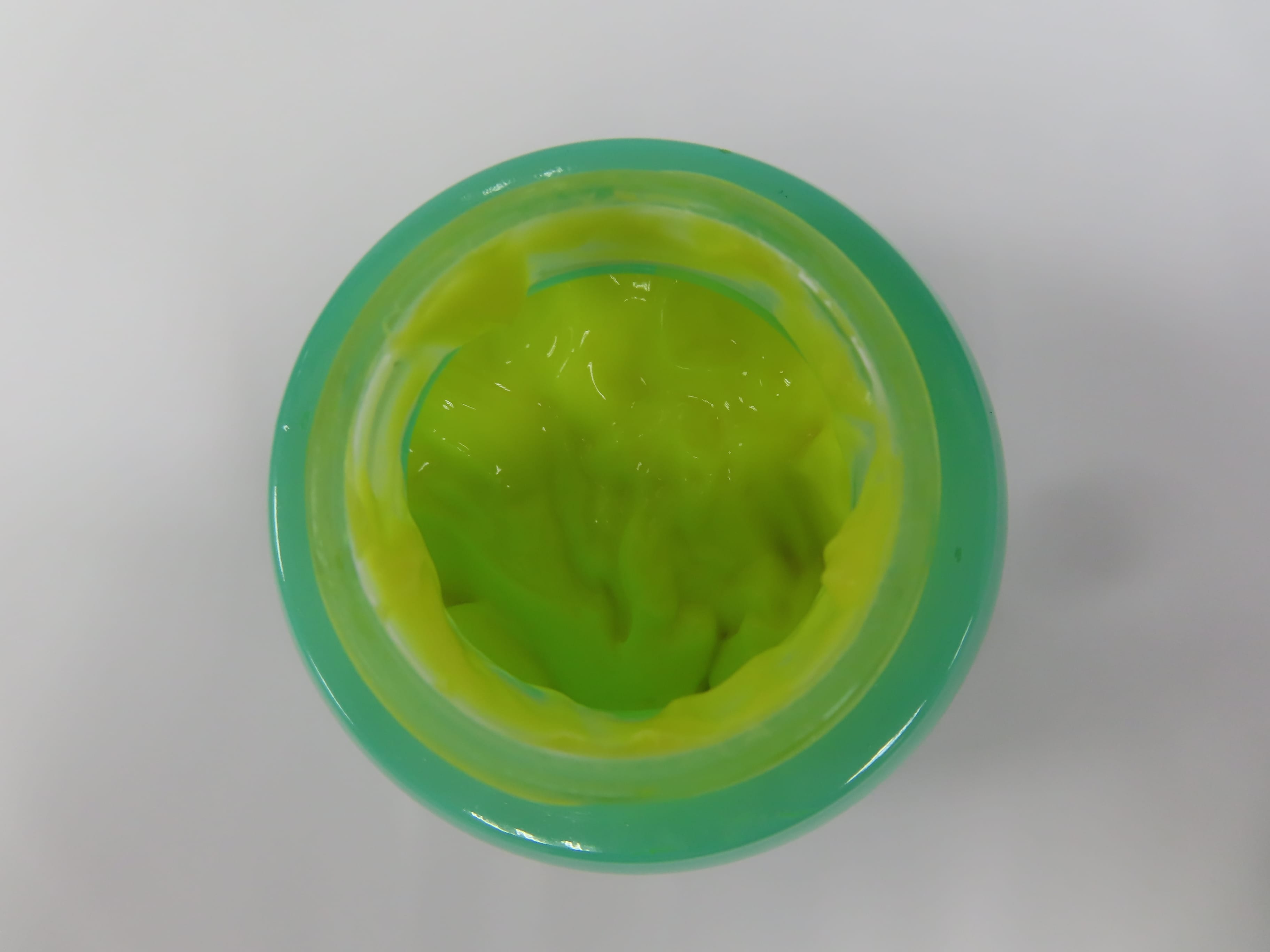 Open jar of Pidekang Dermatitis Cream showing yellow-green cream contents