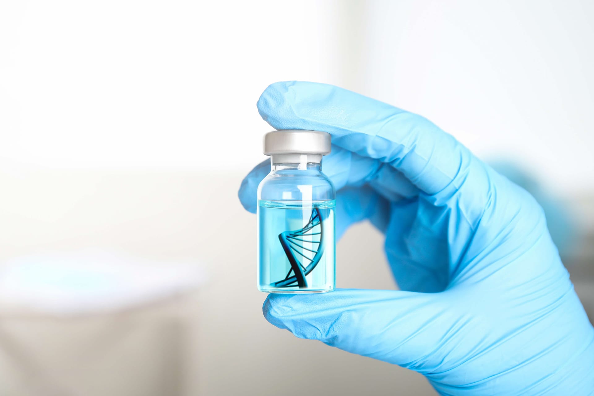Gloved hand holding a vial with DNA symbol, representing cell, tissue and gene therapy products
