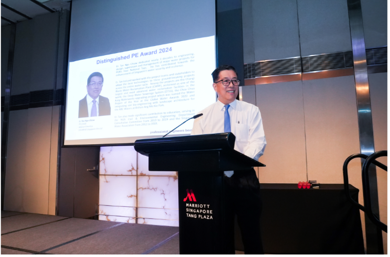 Man speaking at a Marriott Singapore Tang Plaza podium with a Distinguished PE Award 2024 slide projected behind him.