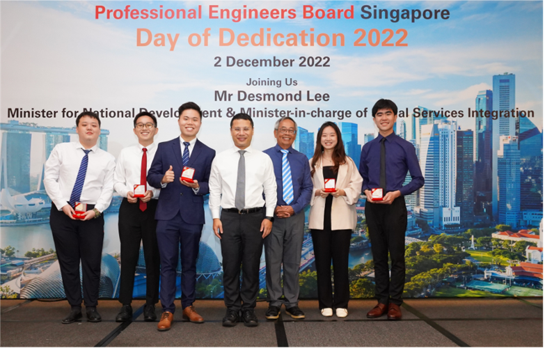 Seven people pose at the Professional Engineers Board Singapore Day of Dedication 2022 event, some holding award boxes.