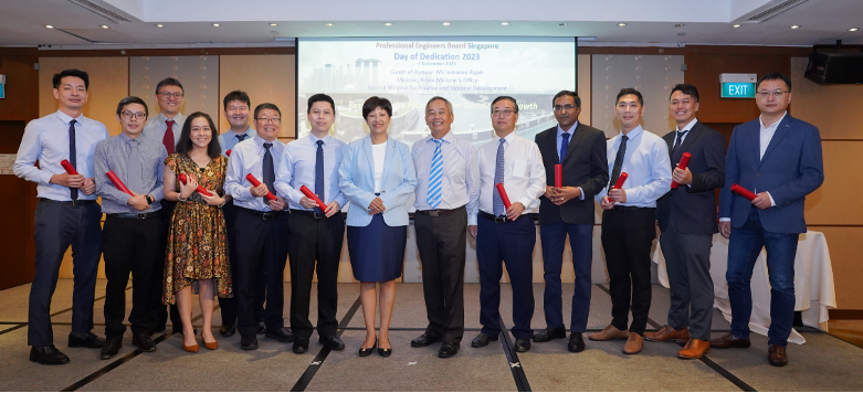 A group of professionals pose with red certificates at the Professional Engineers Board Singapore Day of Dedication 2023.