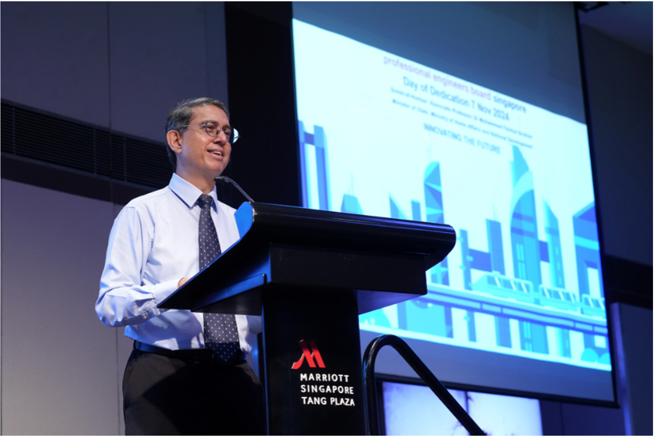 Man in shirt and tie speaks at a Marriott Singapore Tang Plaza podium with a presentation slide behind him.