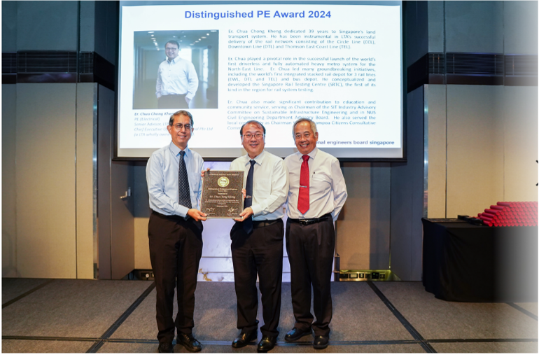 Three men stand together holding a plaque in front of a screen displaying Distinguished PE Award 2024.