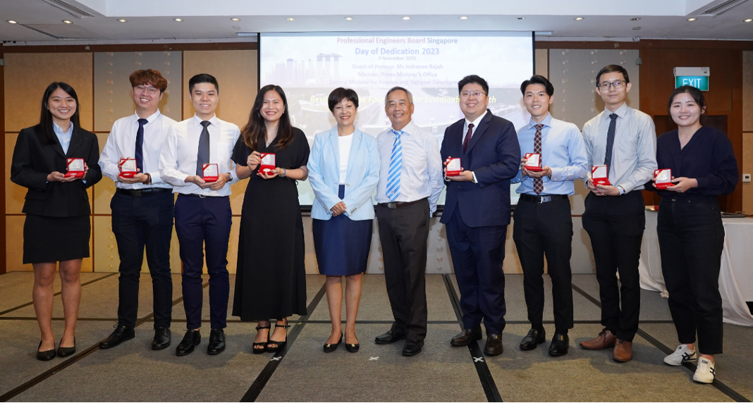 Ten people pose together at the Professional Engineers Board Singapore Day of Dedication 2023, holding red award boxes.
