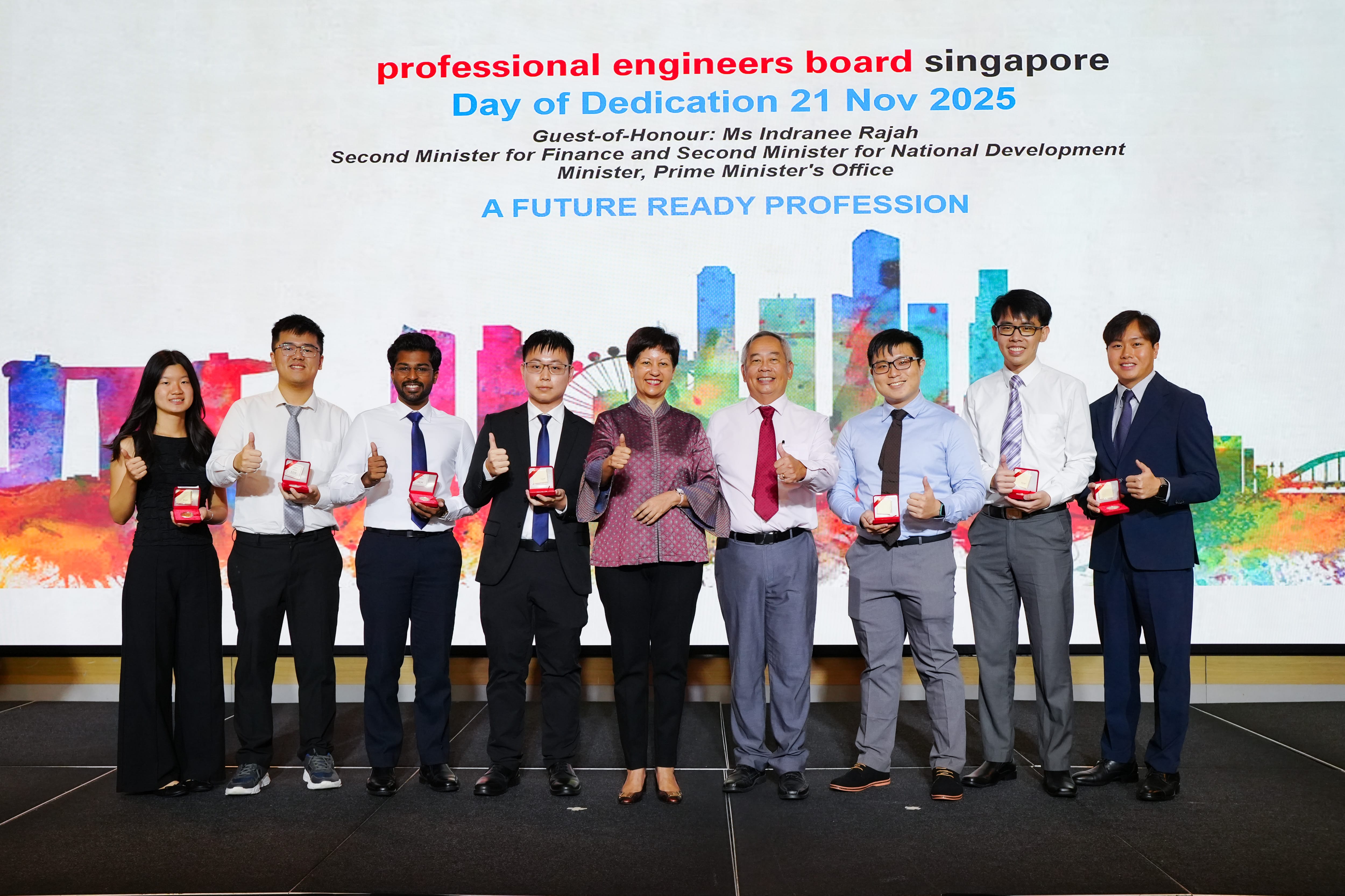 Nine people stand on stage at the Professional Engineers Board Singapore Day of Dedication 2025, holding red award boxes.