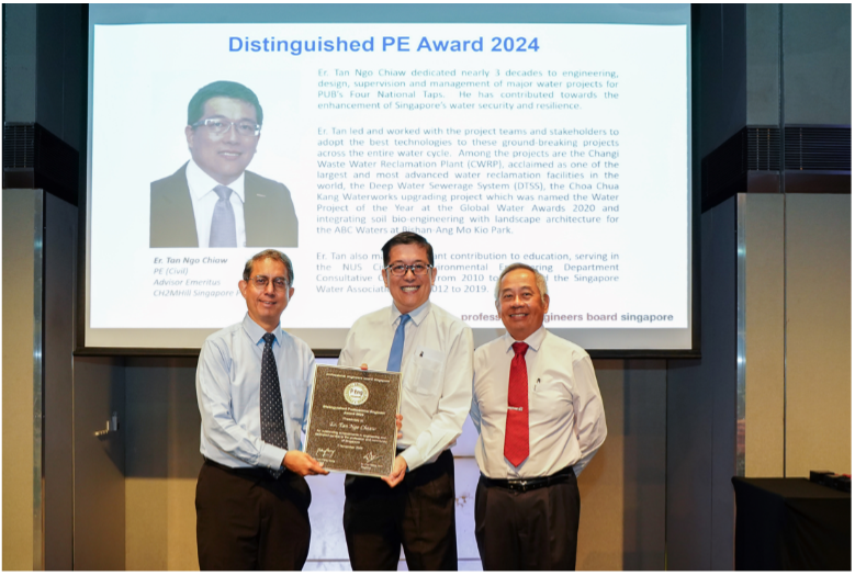 Three men stand together holding an award plaque in front of a Distinguished PE Award 2024 presentation screen.
