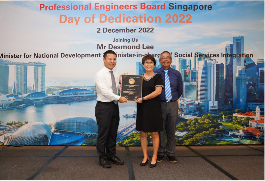 Three people holding a plaque at the Professional Engineers Board Singapore Day of Dedication 2022 event.