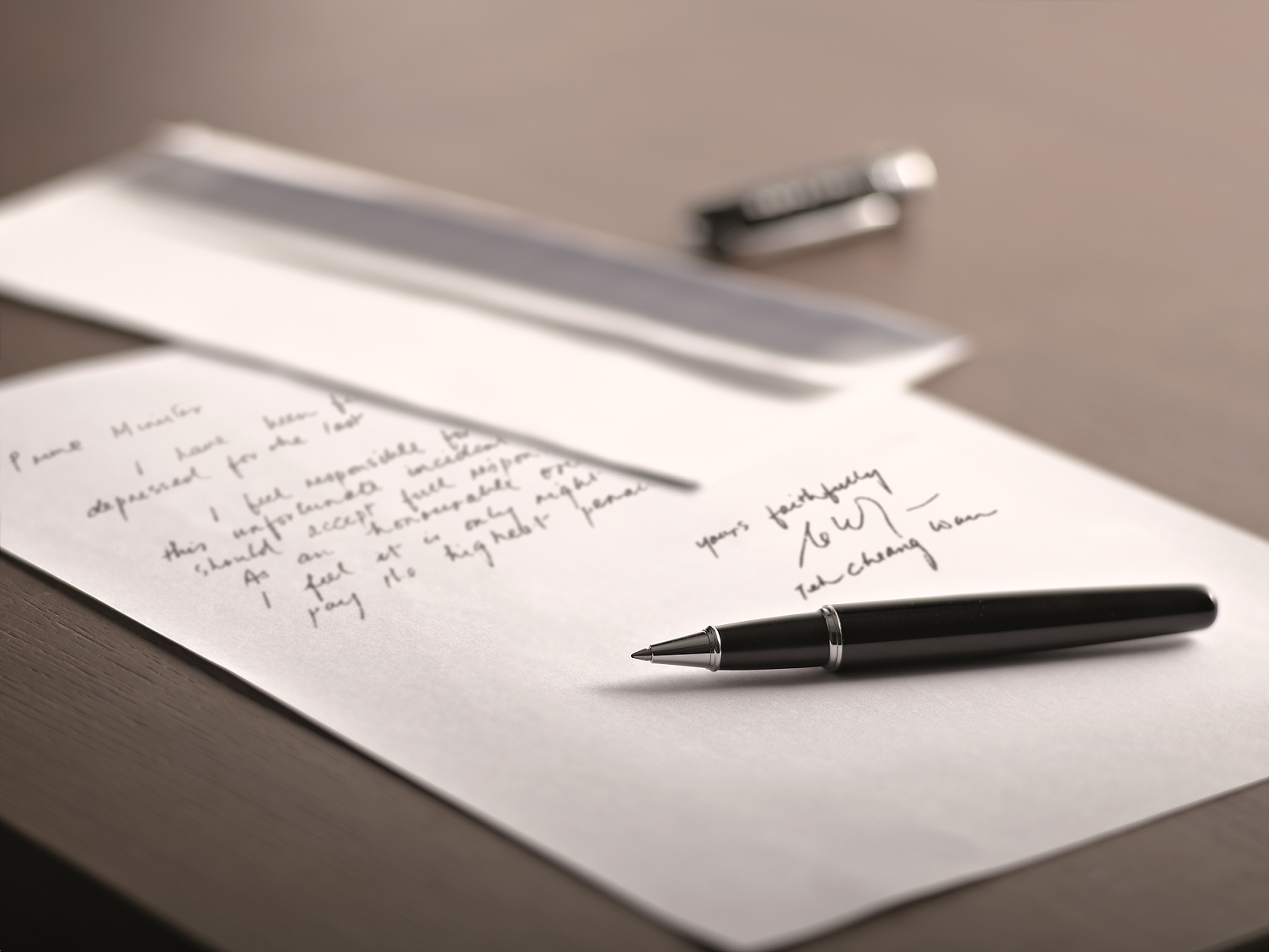 A black rollerball pen resting on a handwritten letter addressed to Prime Minister, signed "yours faithfully."