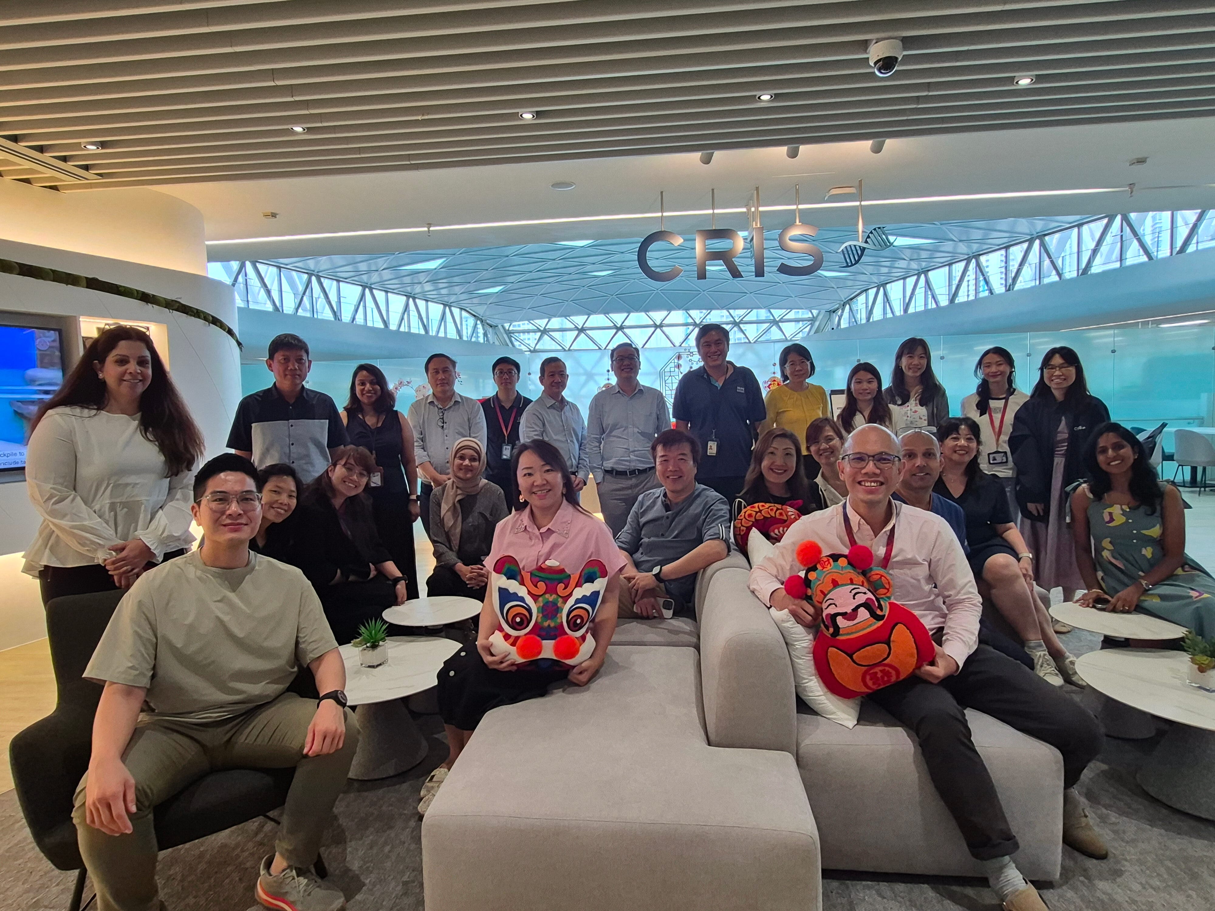A large group of people in formal attire posing in CRIS office