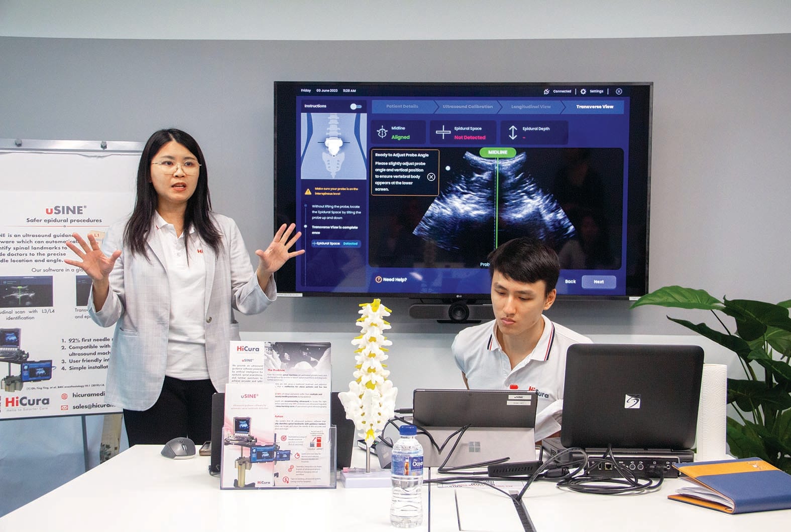 One woman explaining the ultrasound and a man sitting on the table