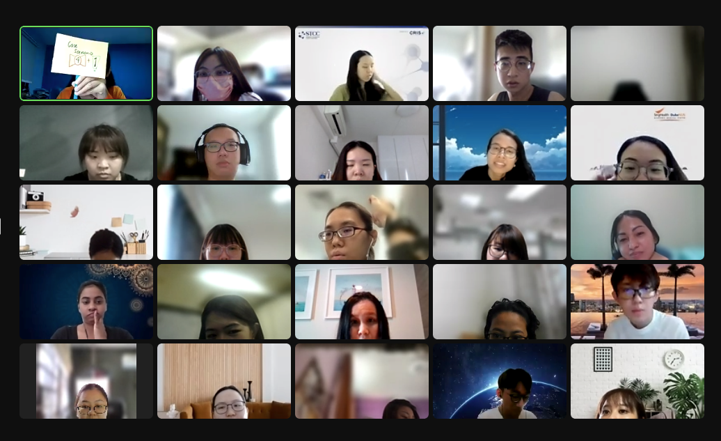 A video call grid showing about 20 participants, mostly young Asian individuals, each in their own camera tile.