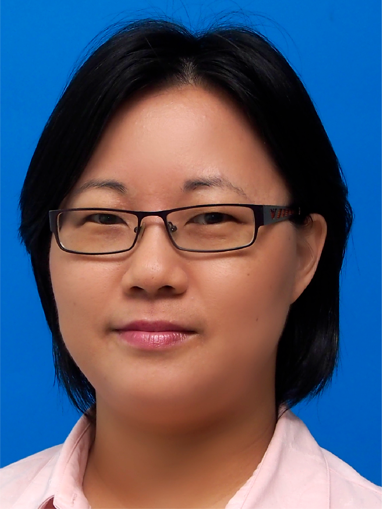 A woman with short black hair and dark-framed glasses faces forward against a bright blue background.