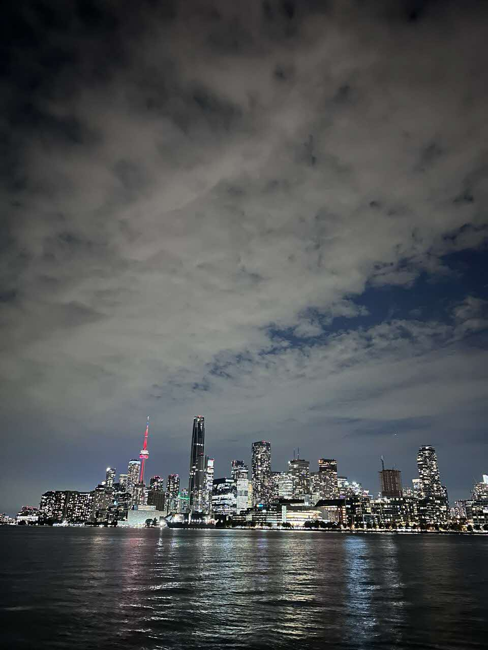 The Toronto skyline lit up at night, seen across the water