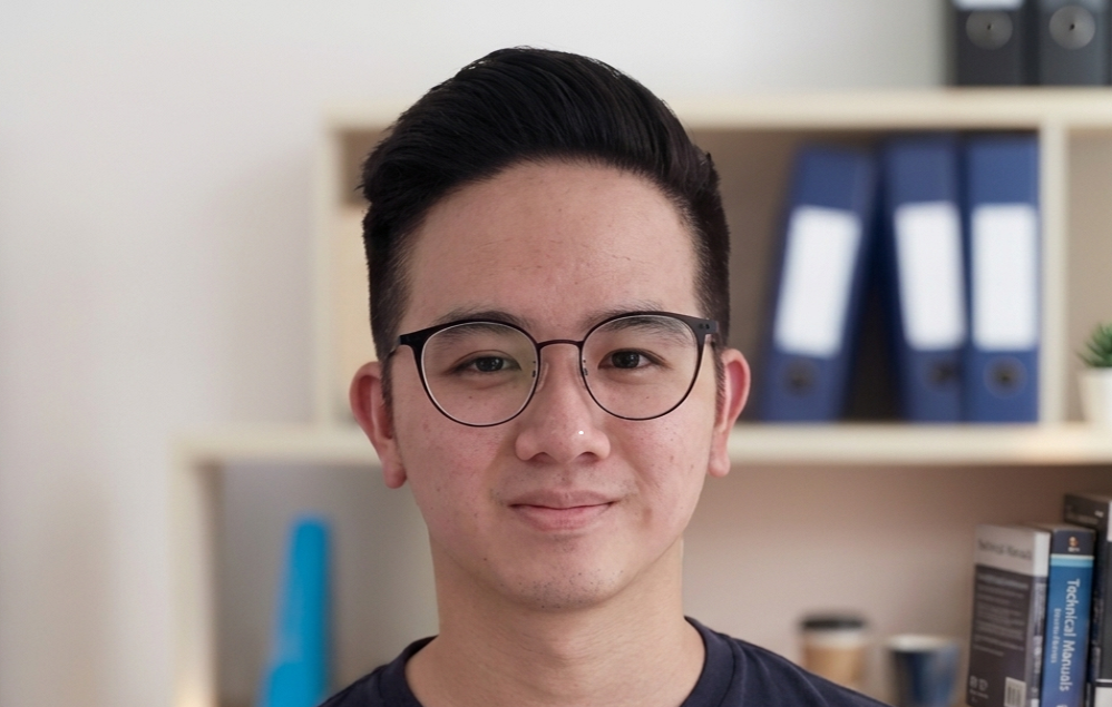 Young smiling Asian man with spectacles and black round neck tee