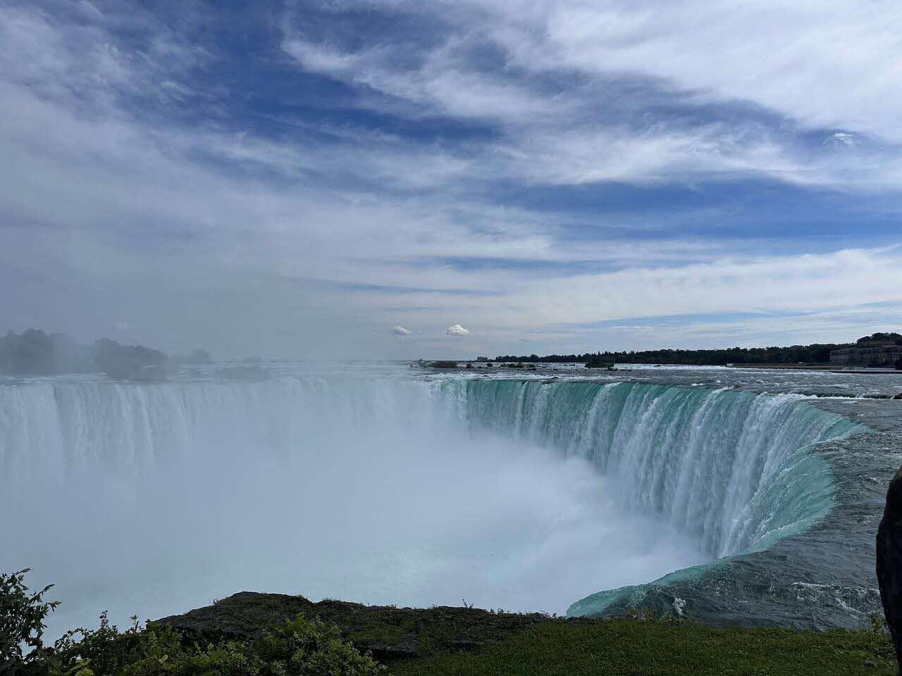 Horseshoe Falls at Niagara Falls under a blue sky with scattered clouds