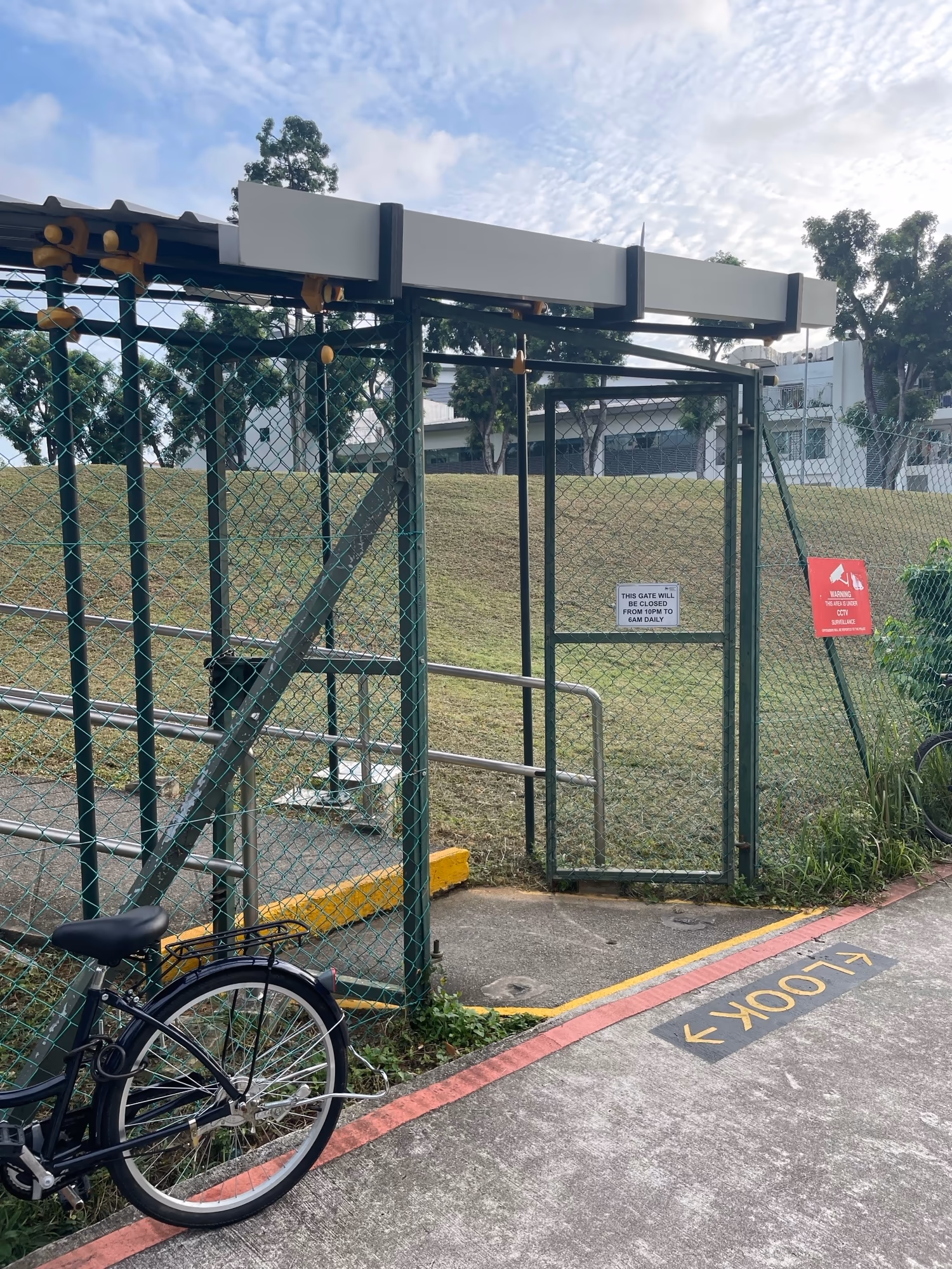 Entrance of Buangkok Green Medical Park with an Institute of Mental Health welcome banner, bicycles parked nearby.
