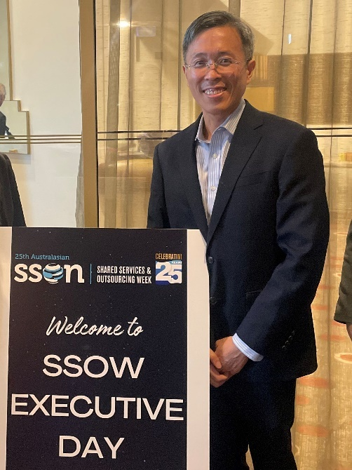 Man in a black blazer smiling beside a sign reading Welcome to SSOW Executive Day at the 25th SSON event.