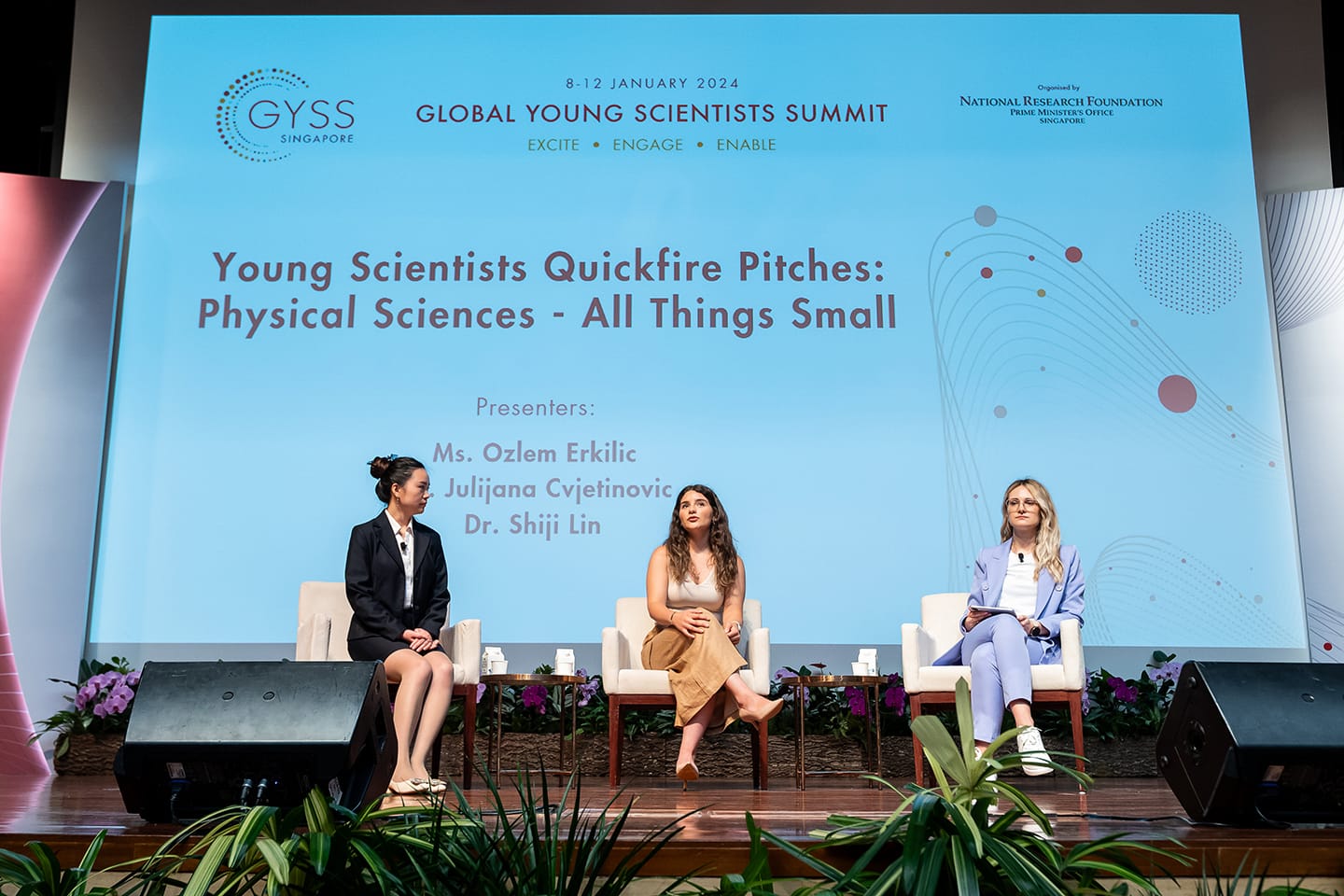 Three women sit on stage at the 2024 Global Young Scientists Summit during a Physical Sciences quickfire pitch session.